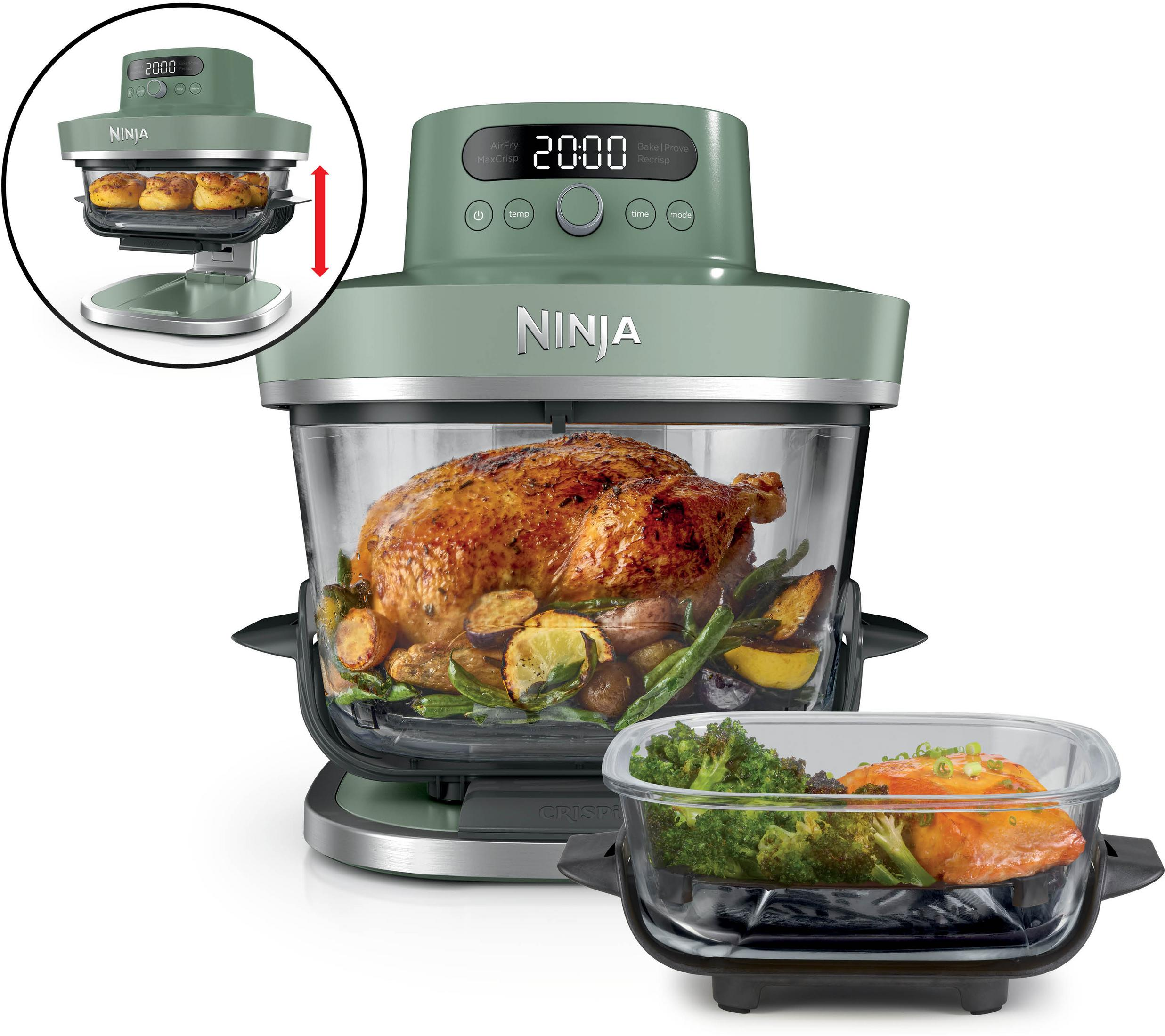 Ein grüner Ninja Foodi mit einem gebratenen Huhn und Gemüse. Daneben ein Glasbehälter mit Lachs und Brokkoli.