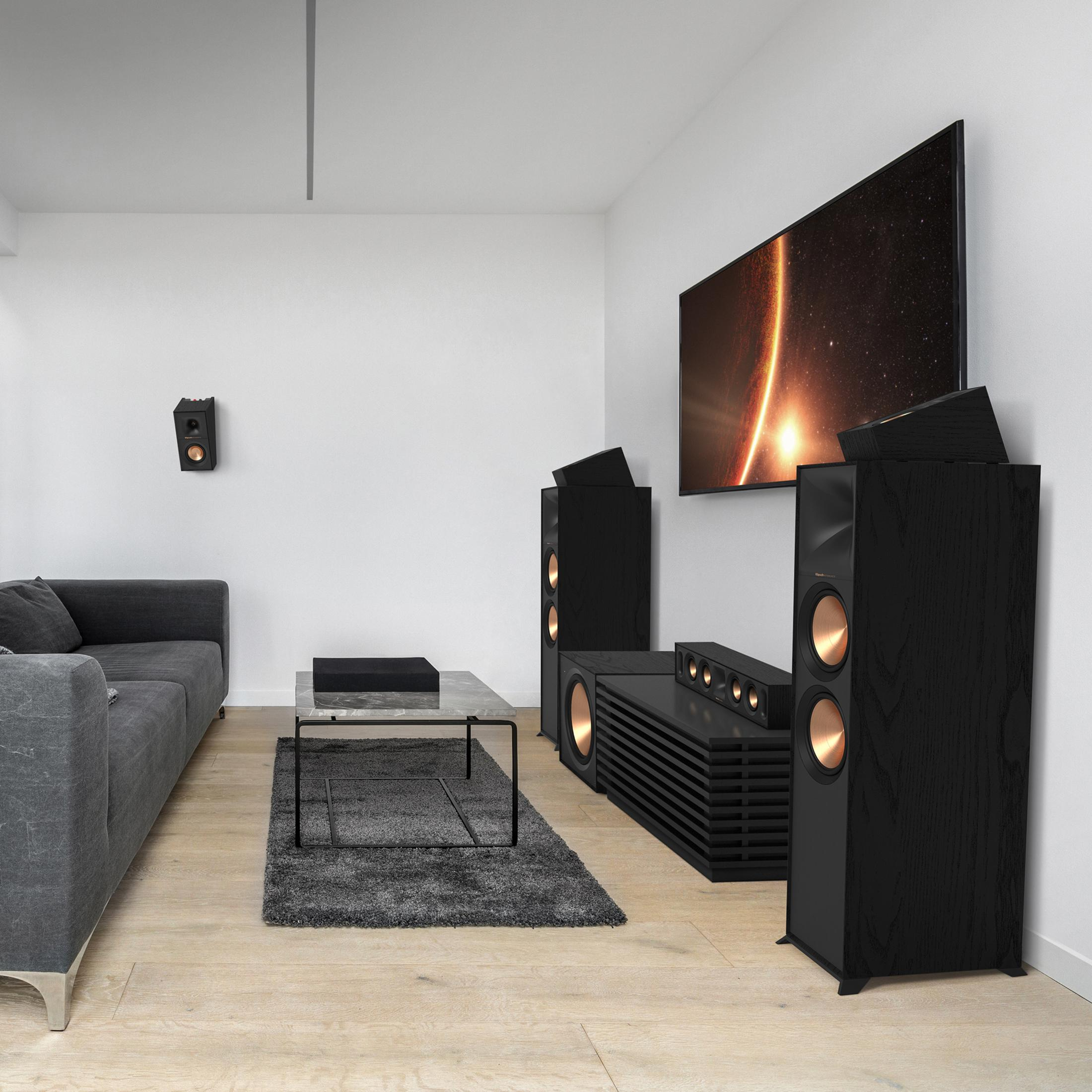 Sofa, sehpa, TV ve çok sayıda hoparlör bulunan siyah oturma odası.