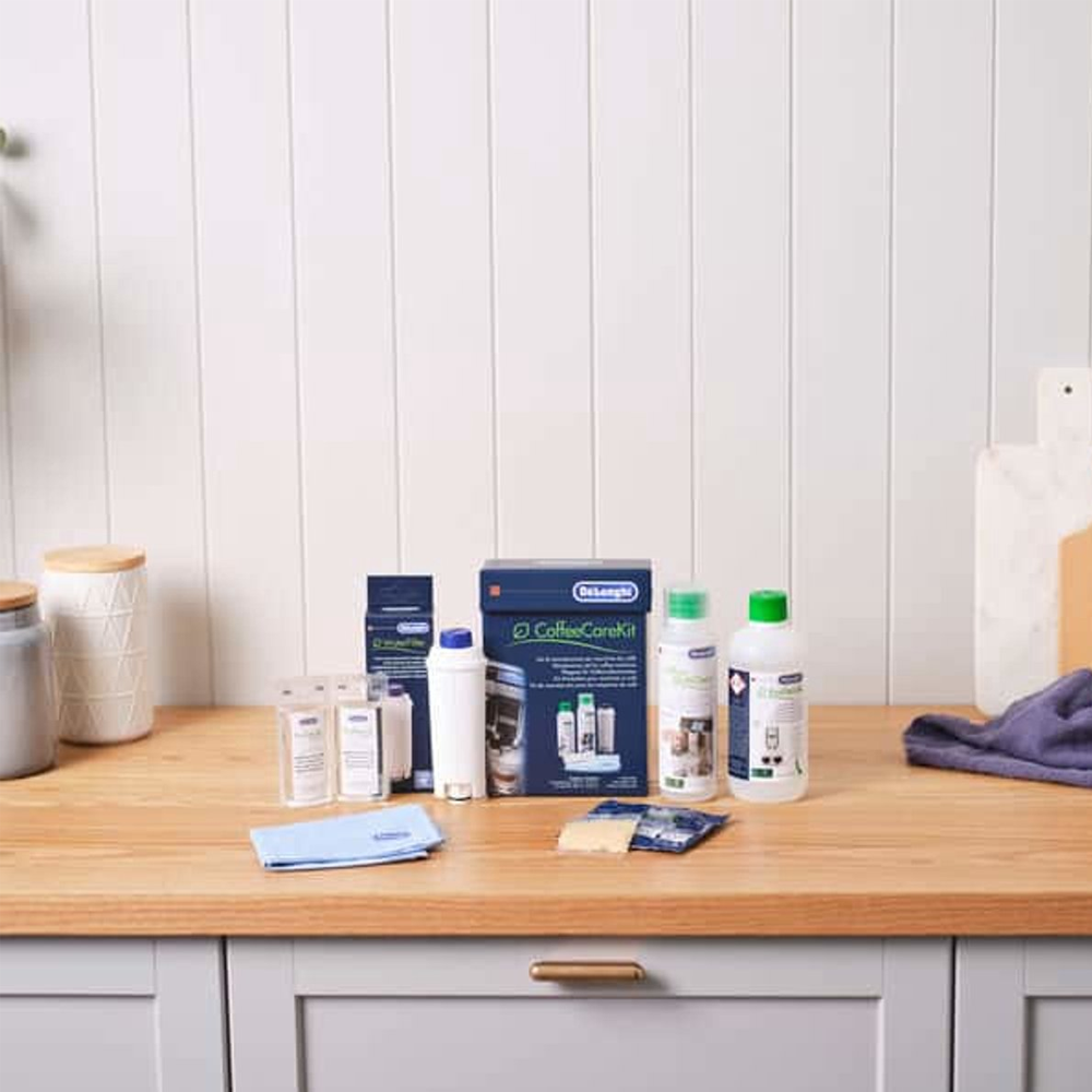 Coffee care kit with filters and cleaning solutions on a wooden countertop.
