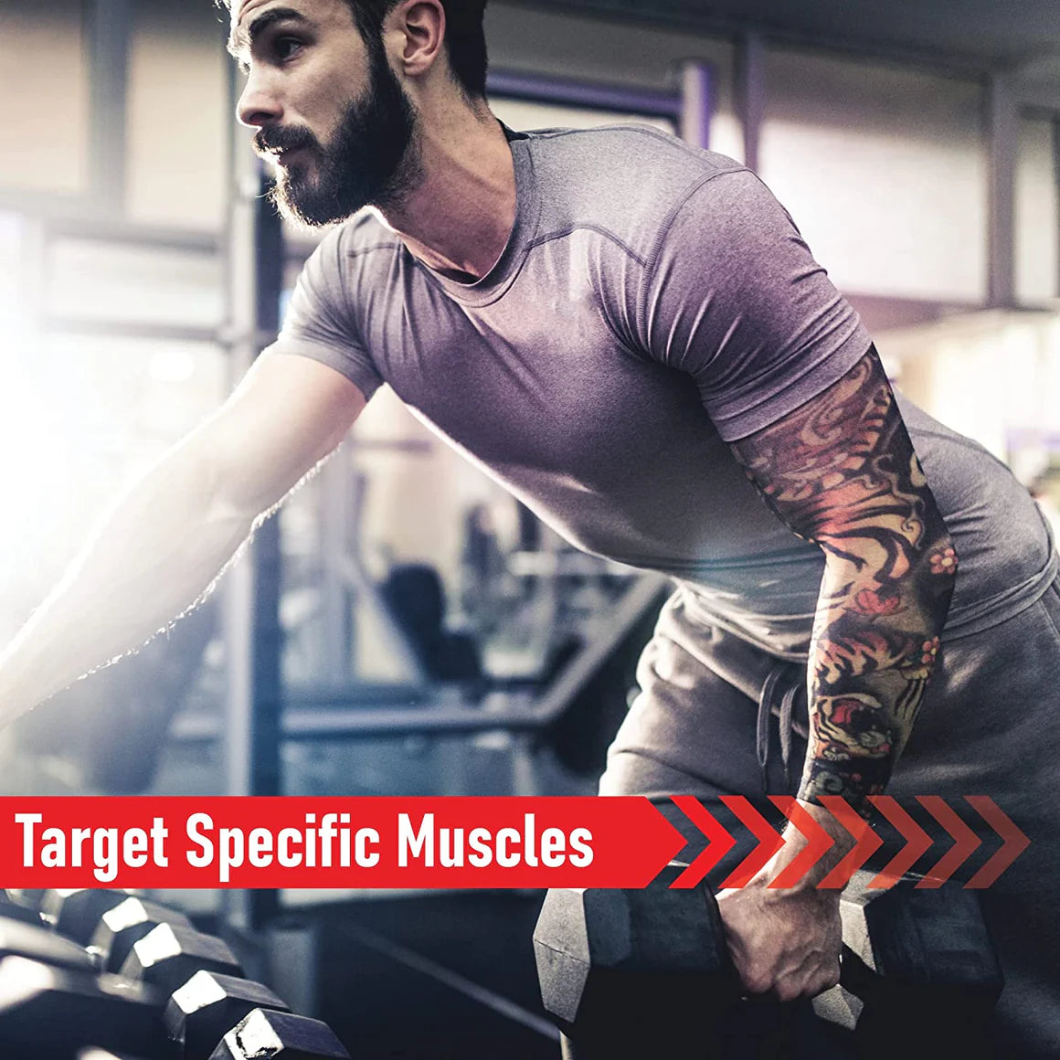 Hombre con tatuajes levanta mancuerna en gimnasio.