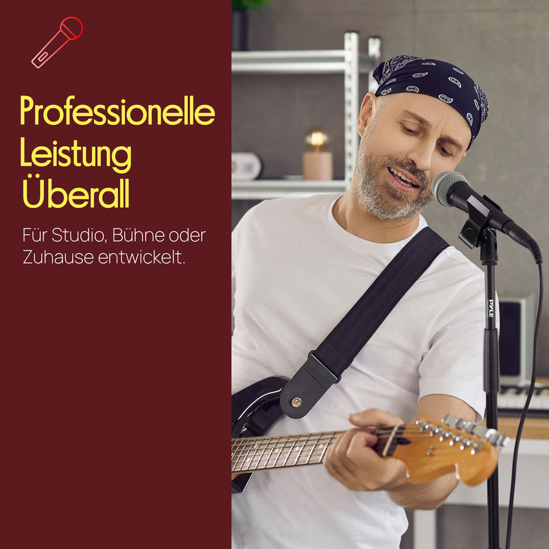 Mann mit Gitarre und Mikrofon, singt vor einem Mikrofonständer.