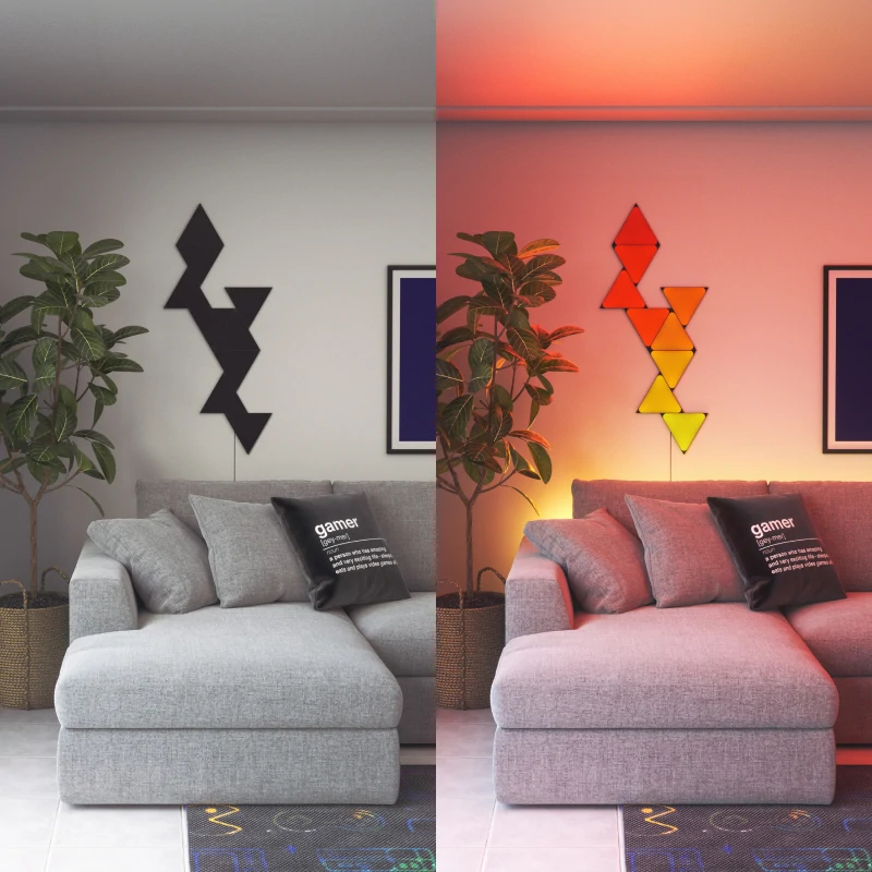 Graues Sofa mit zwei Pflanzen und Wandleuchten, links schwarz, rechts farbig.