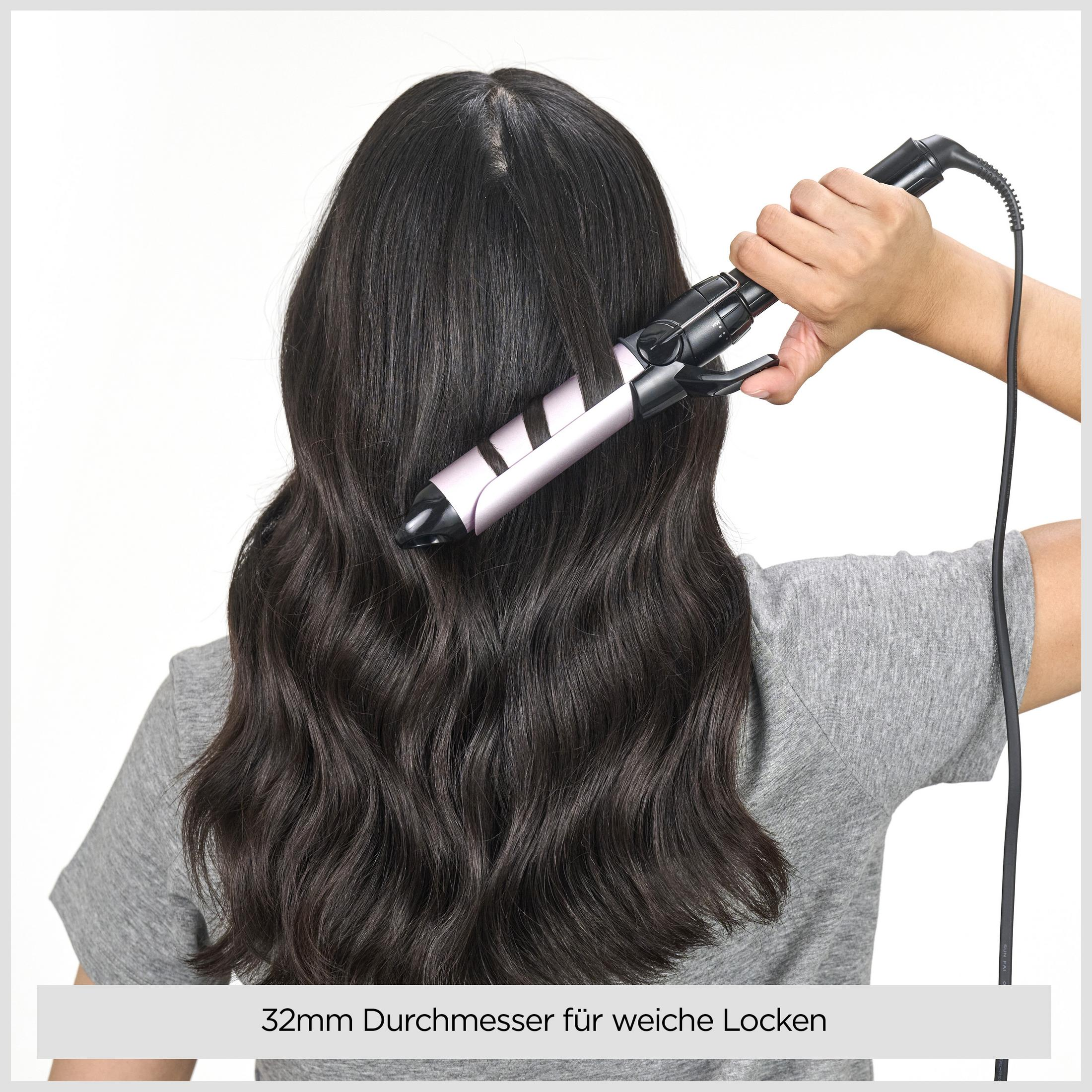 Una mano sostiene un rizador, formando ondas suaves en cabello oscuro.