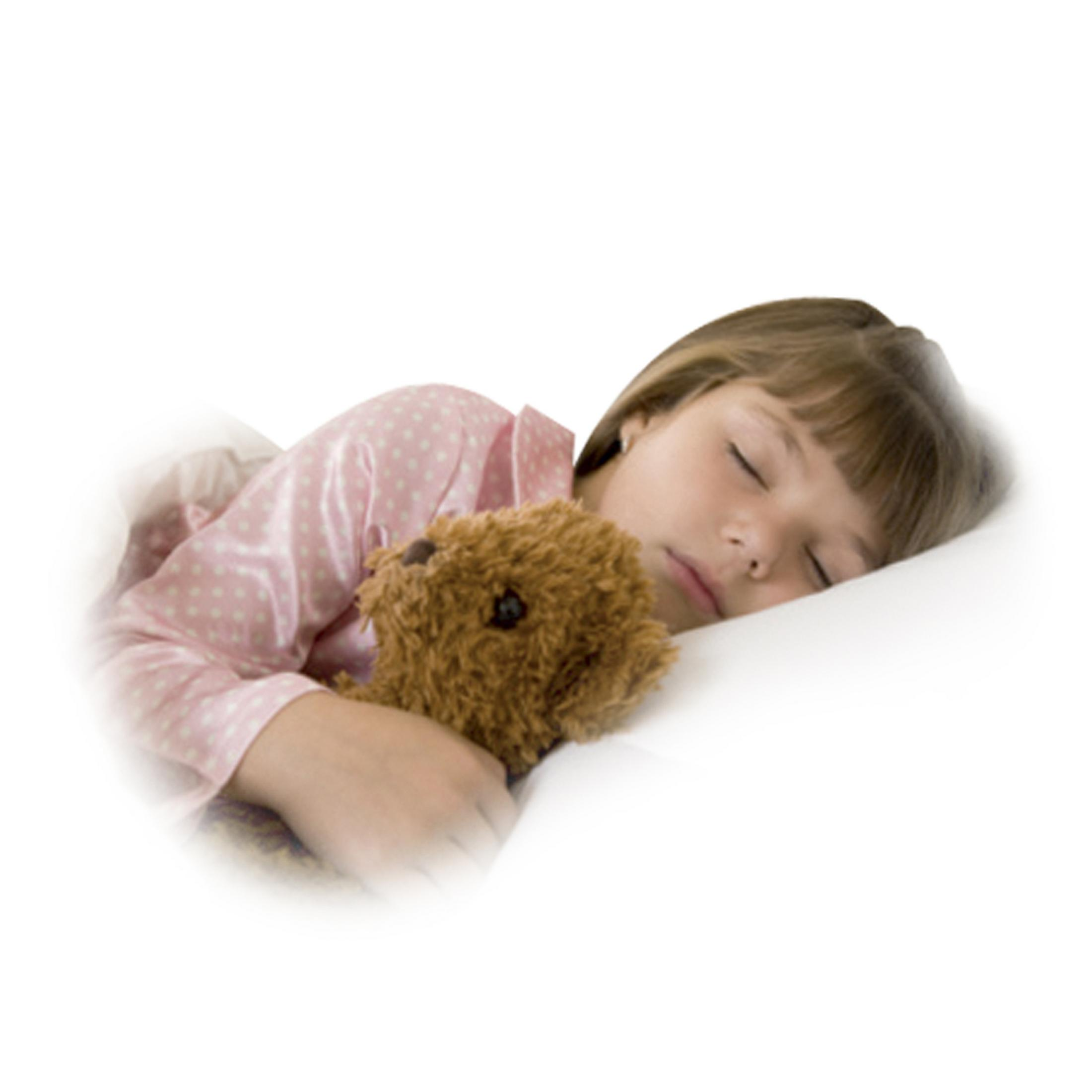 Ein kleines Mädchen schläft mit einem Teddybär im Arm auf einem weißen Kissen.