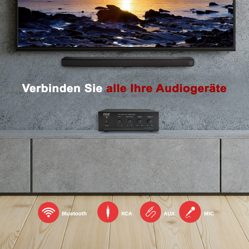 Ein kleiner Verstärker steht auf einem Schrank vor einem Fernseher.