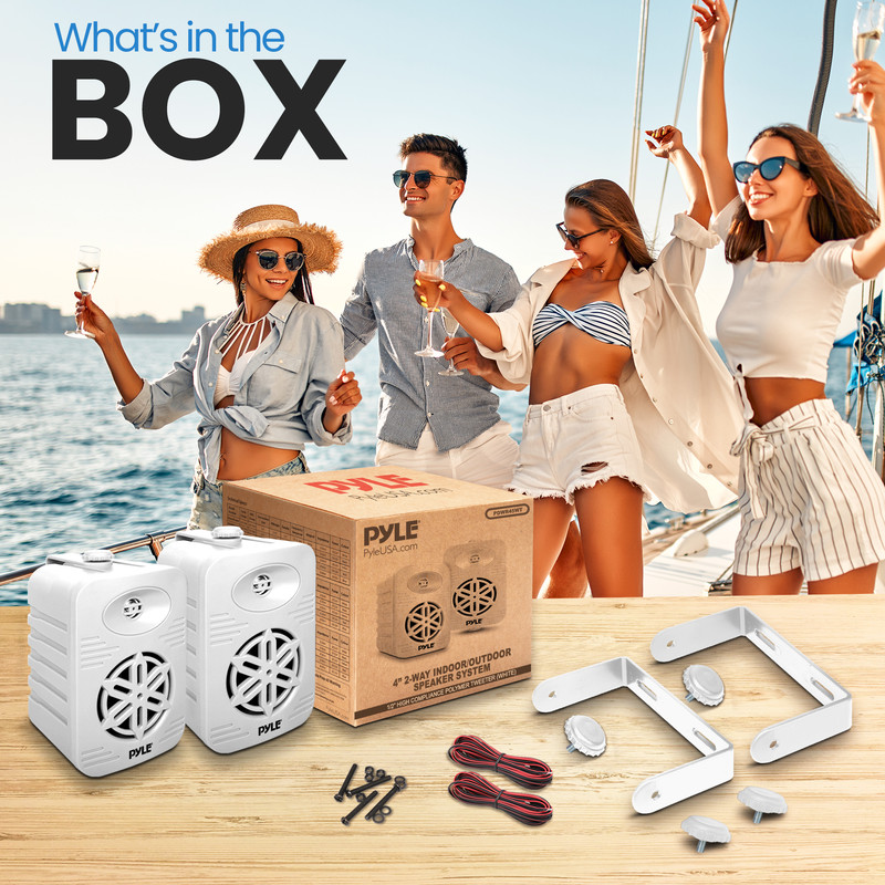 Ein Paket mit Lautsprechern und Zubehör auf einem Tisch, Leute auf einem Boot im Hintergrund.