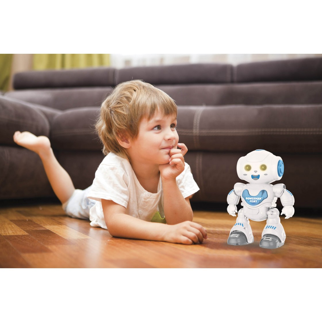 Ein Junge liegt auf dem Boden und schaut einen weißen Roboter an.
