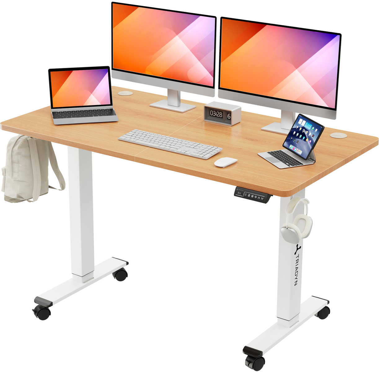 Biurko z regulacją wysokości z dwoma monitorami, laptopami, klawiaturą, myszą i plecakiem.