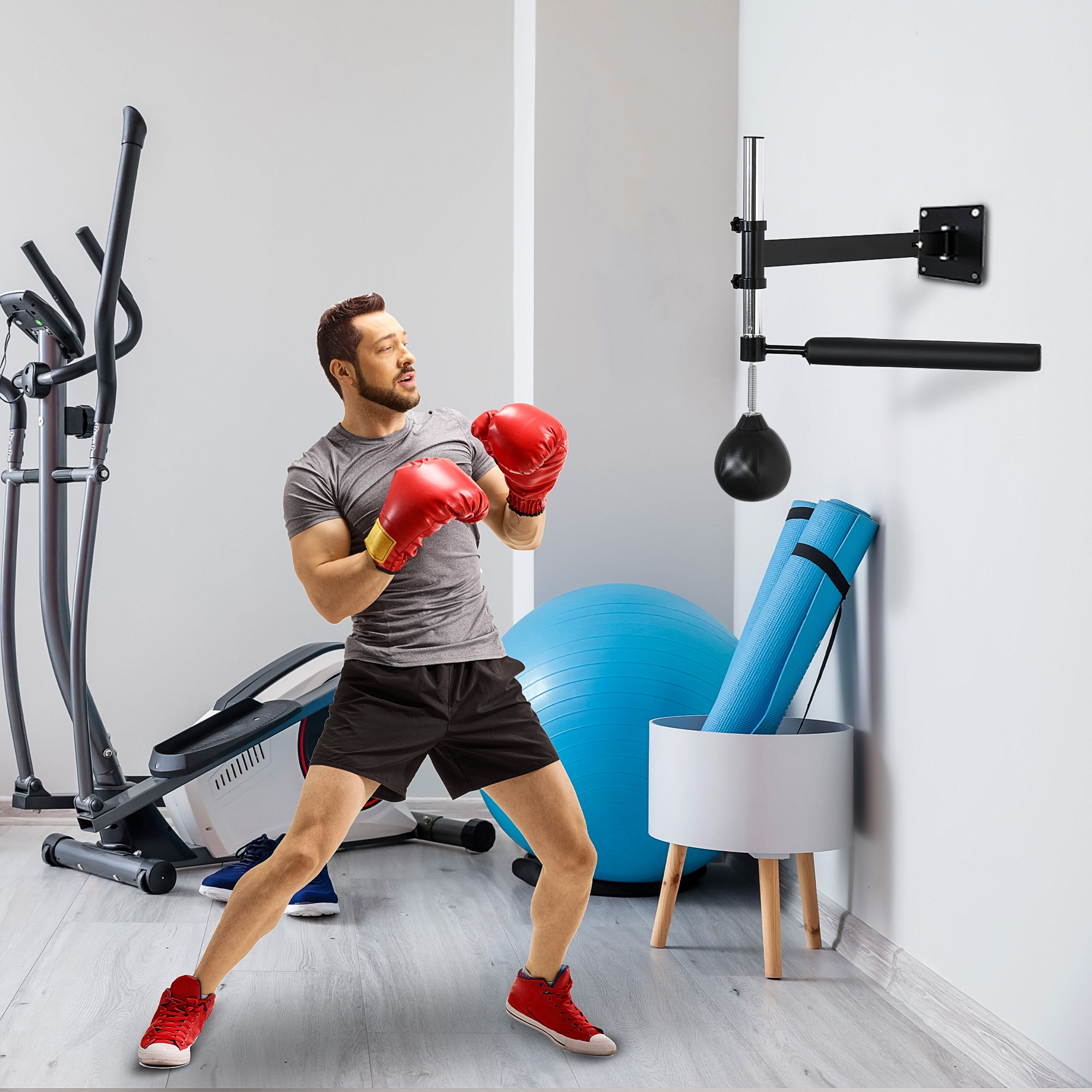 Un uomo con guantoni da boxe si allena con un sacco da pugilato in una palestra.