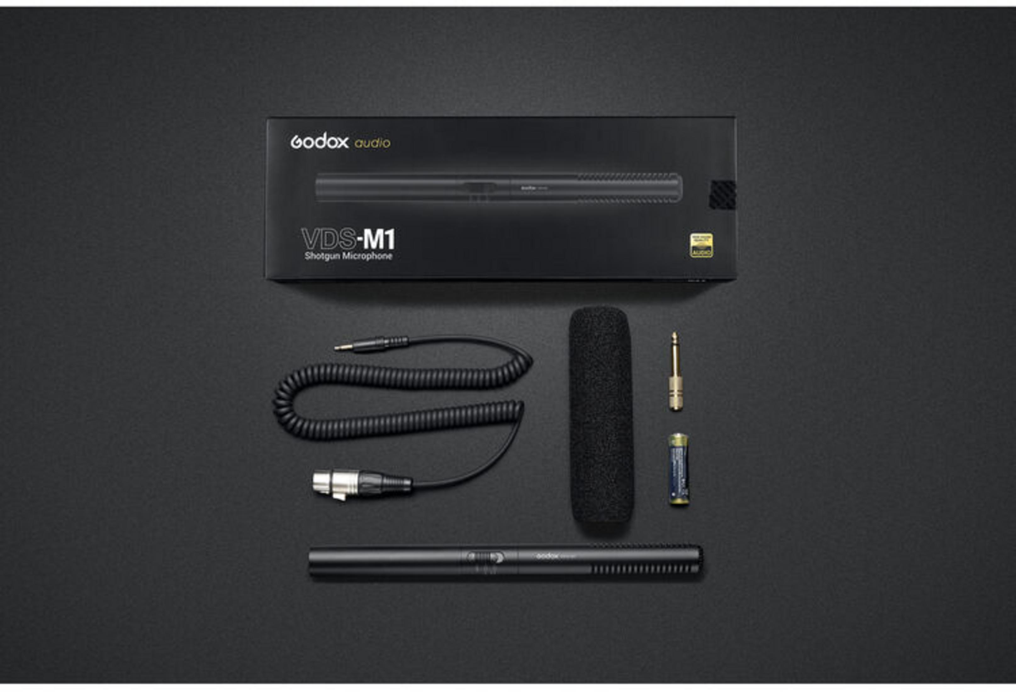 Godox VDS-M1 Shotgun Mikrofon, Zubehör, und Verpackung auf schwarzem Hintergrund.