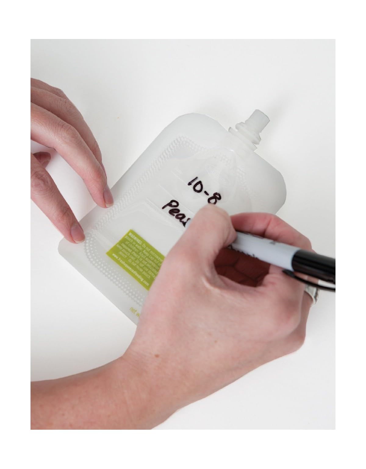 Eine Hand beschriftet einen Beutel mit einem Marker.