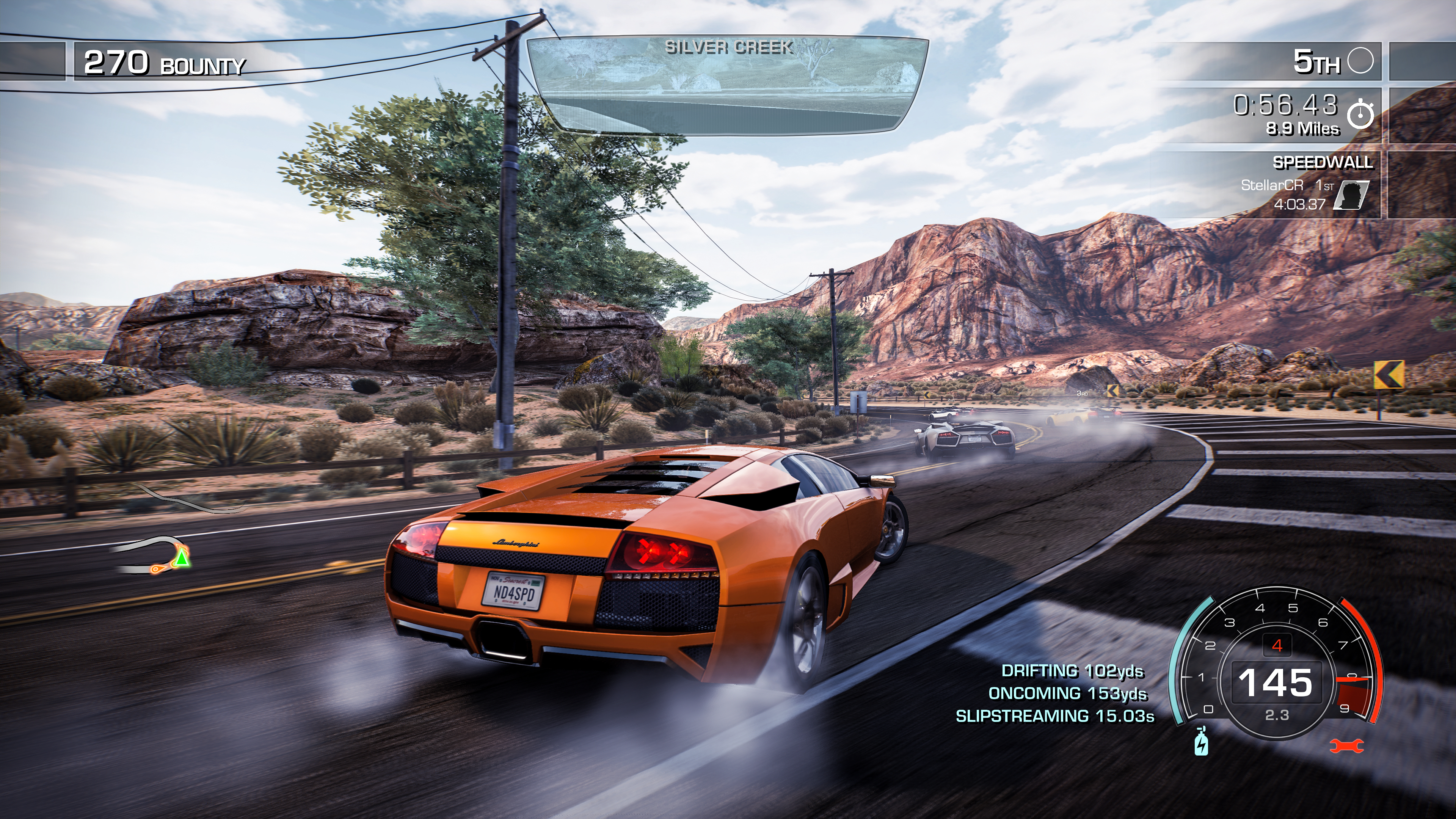 Un'arancione Lamborghini corre su una strada di montagna vicino a Silver Creek. Diverse auto sono visibili.