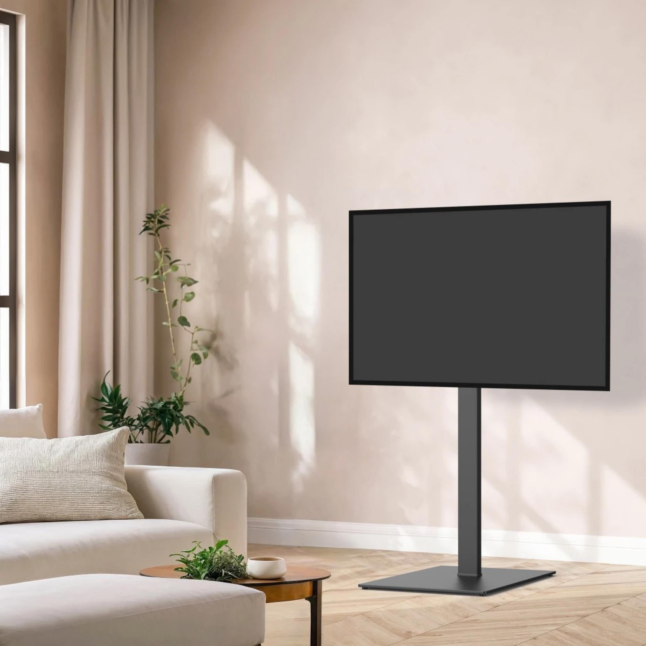 Ein moderner schwarzer TV-Ständer trägt einen großen schwarzen Fernseher in einem Wohnzimmer mit cremefarbener Couch.