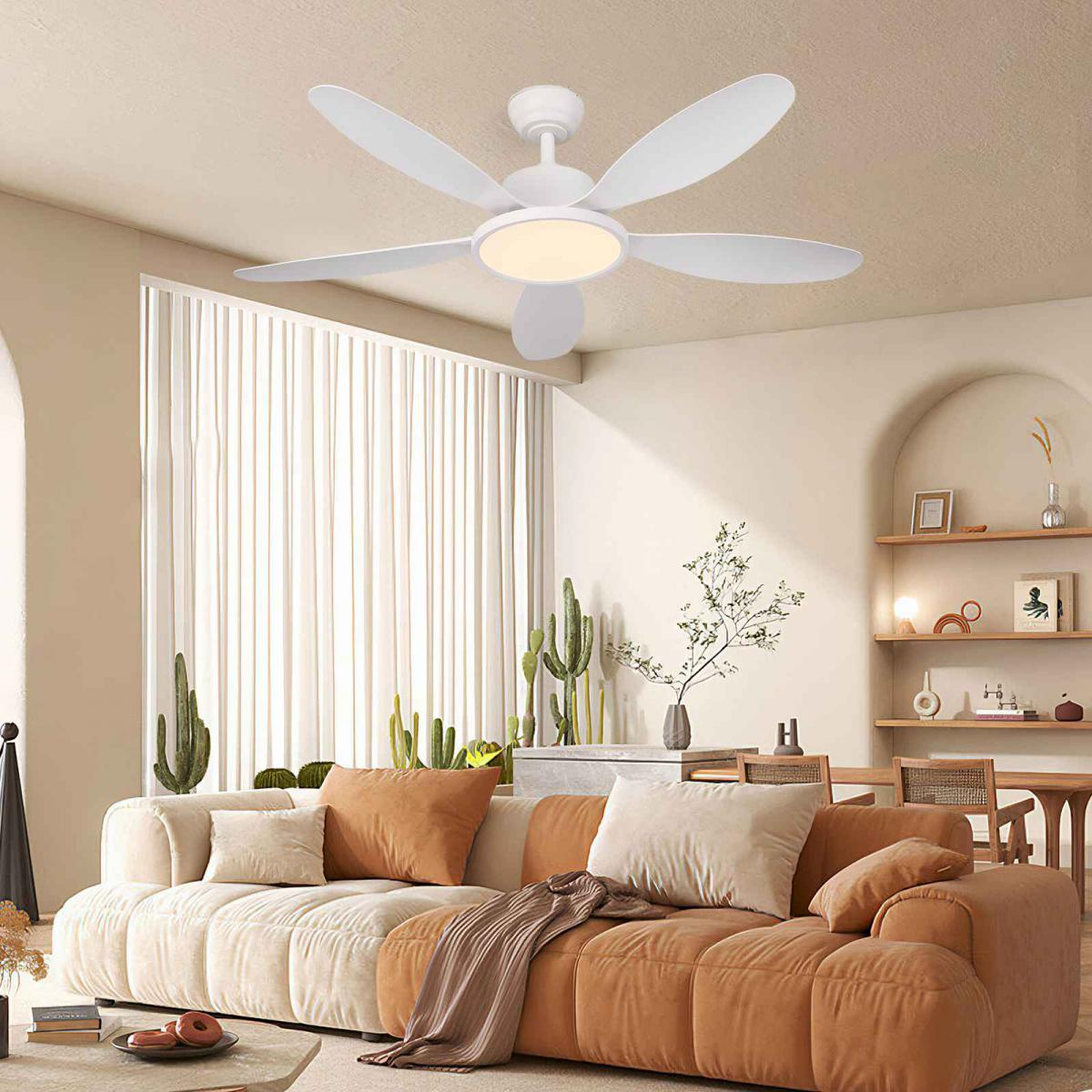 Ein weißer Deckenventilator mit Licht über einem Sofa mit braunen und cremefarbenen Kissen.