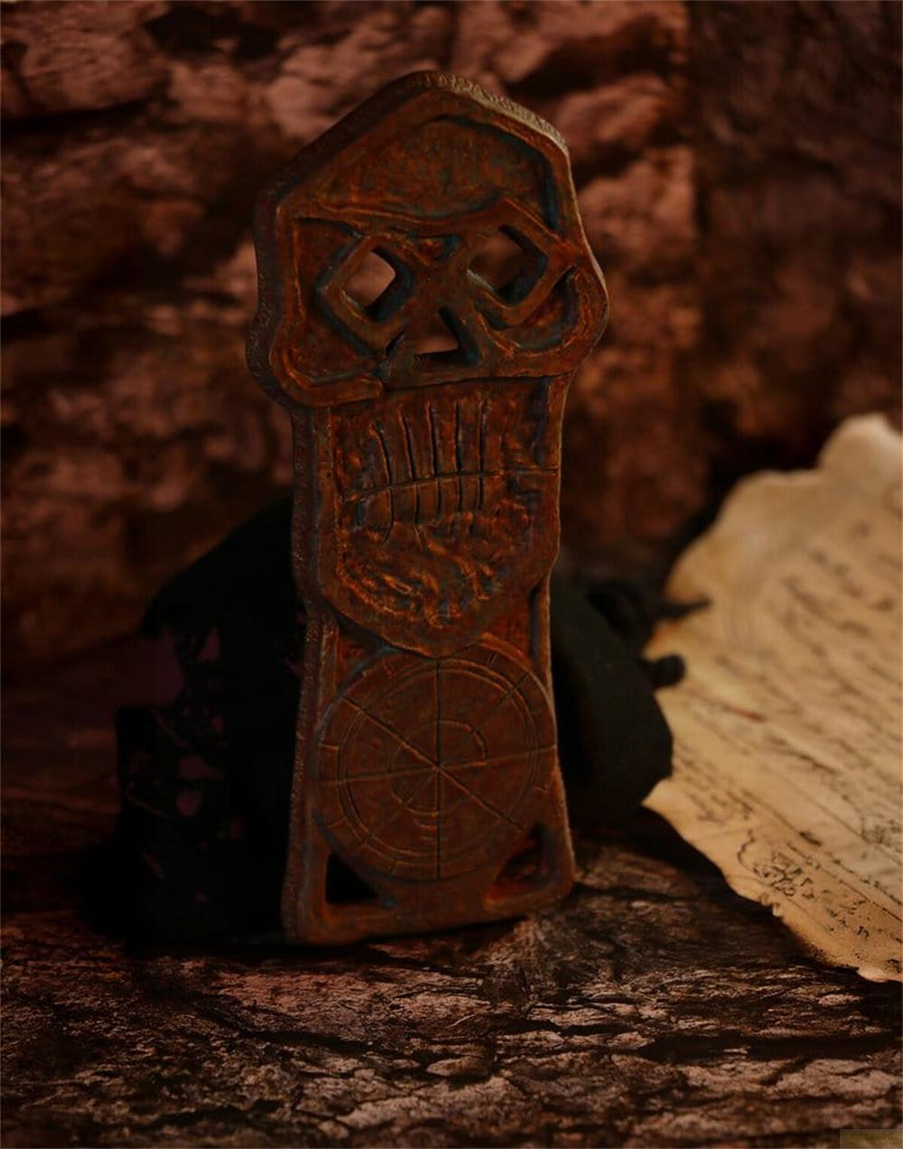 Ein antiker Totenkopf-Anhänger mit einem Kompass-Muster auf einer Karte.