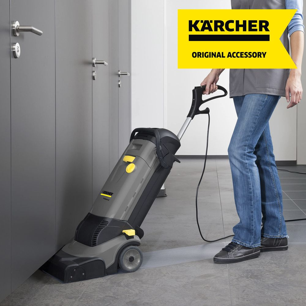 Eine Person benutzt einen Kärcher Bodenreiniger neben grauen Türen.