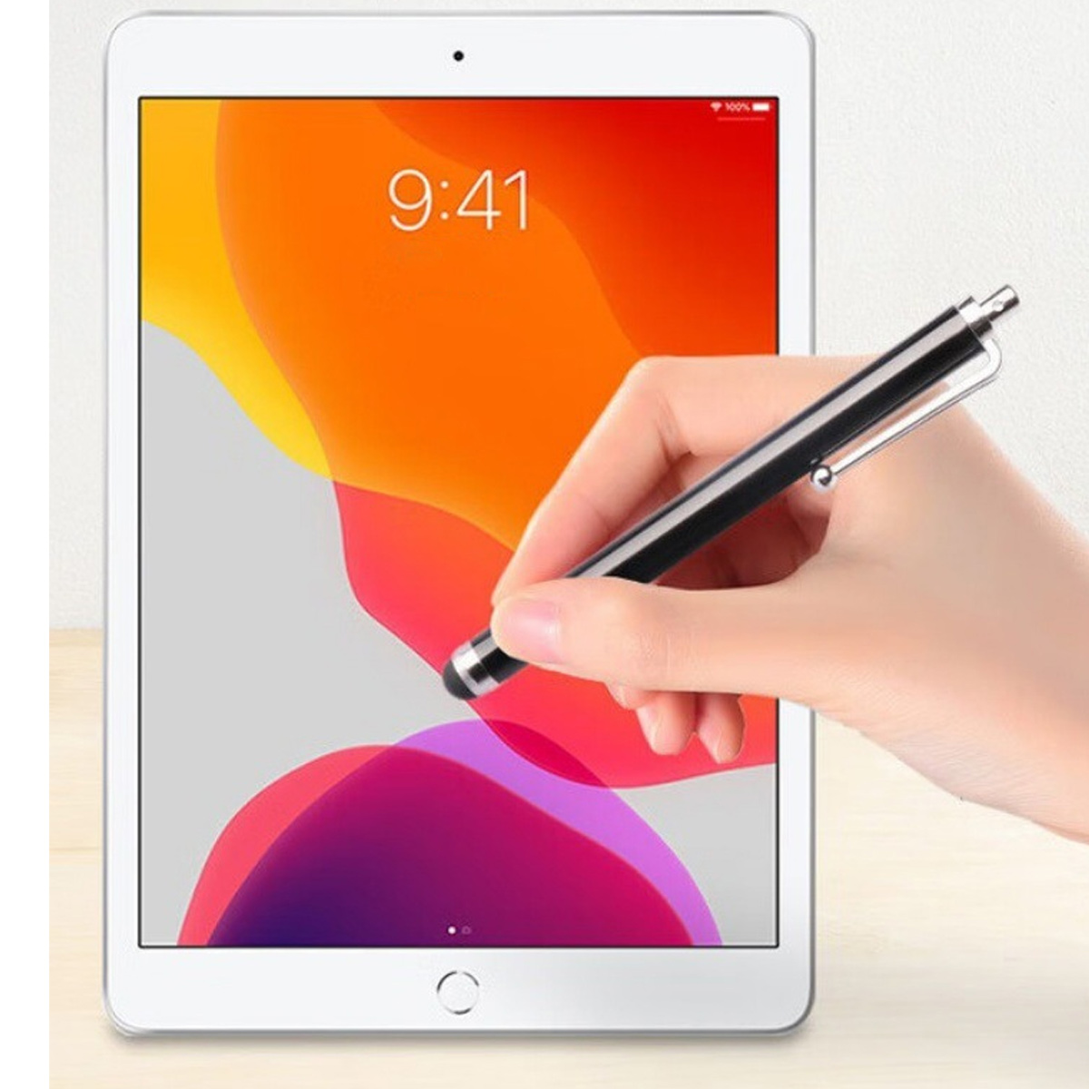 Eine Hand benutzt einen schwarzen Stift, um auf einem Tablet mit bunter Hintergrundgrafik zu tippen.