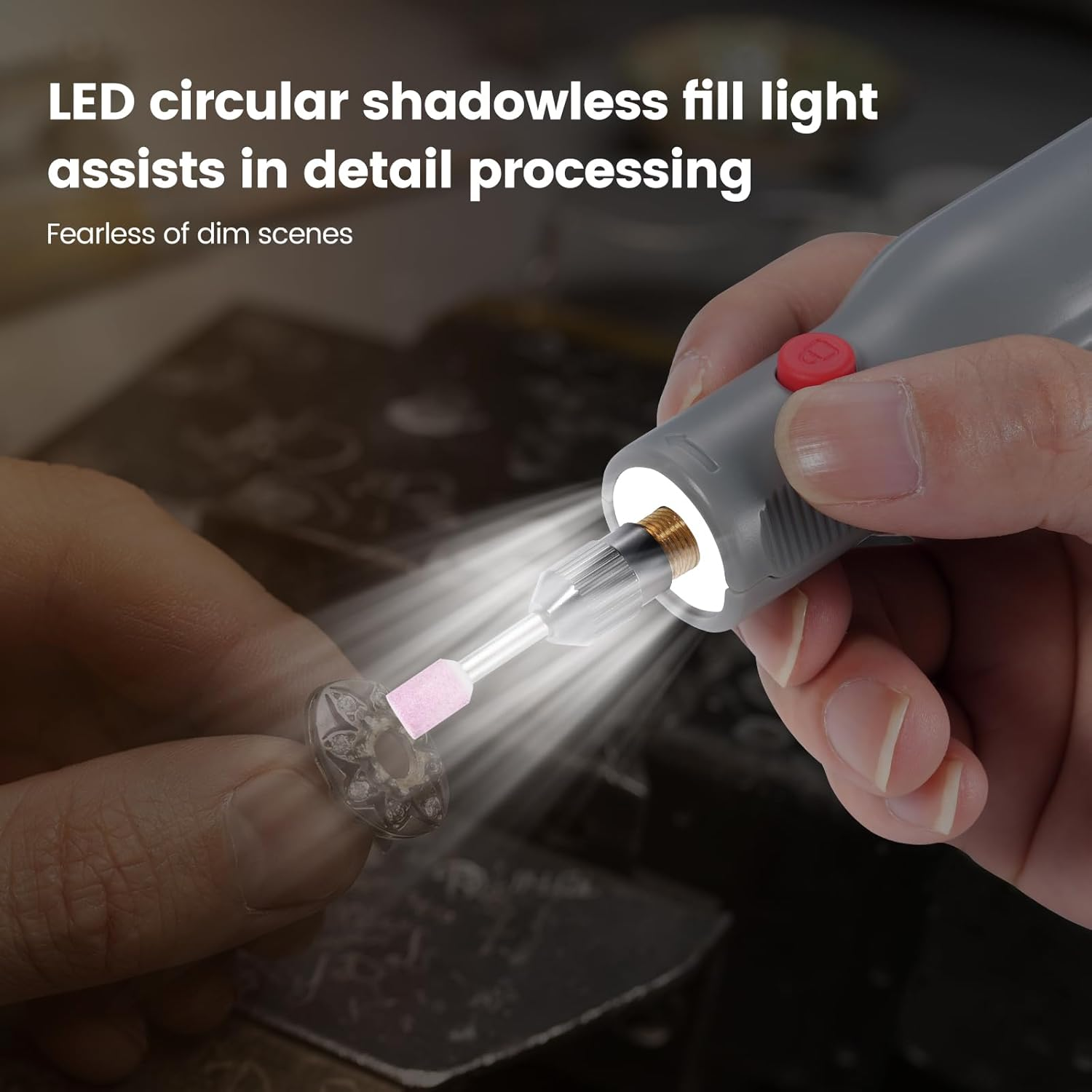 Eine Hand hält ein graues Rotationswerkzeug mit LED-Licht, das ein kleines, verziertes Objekt beleuchtet.