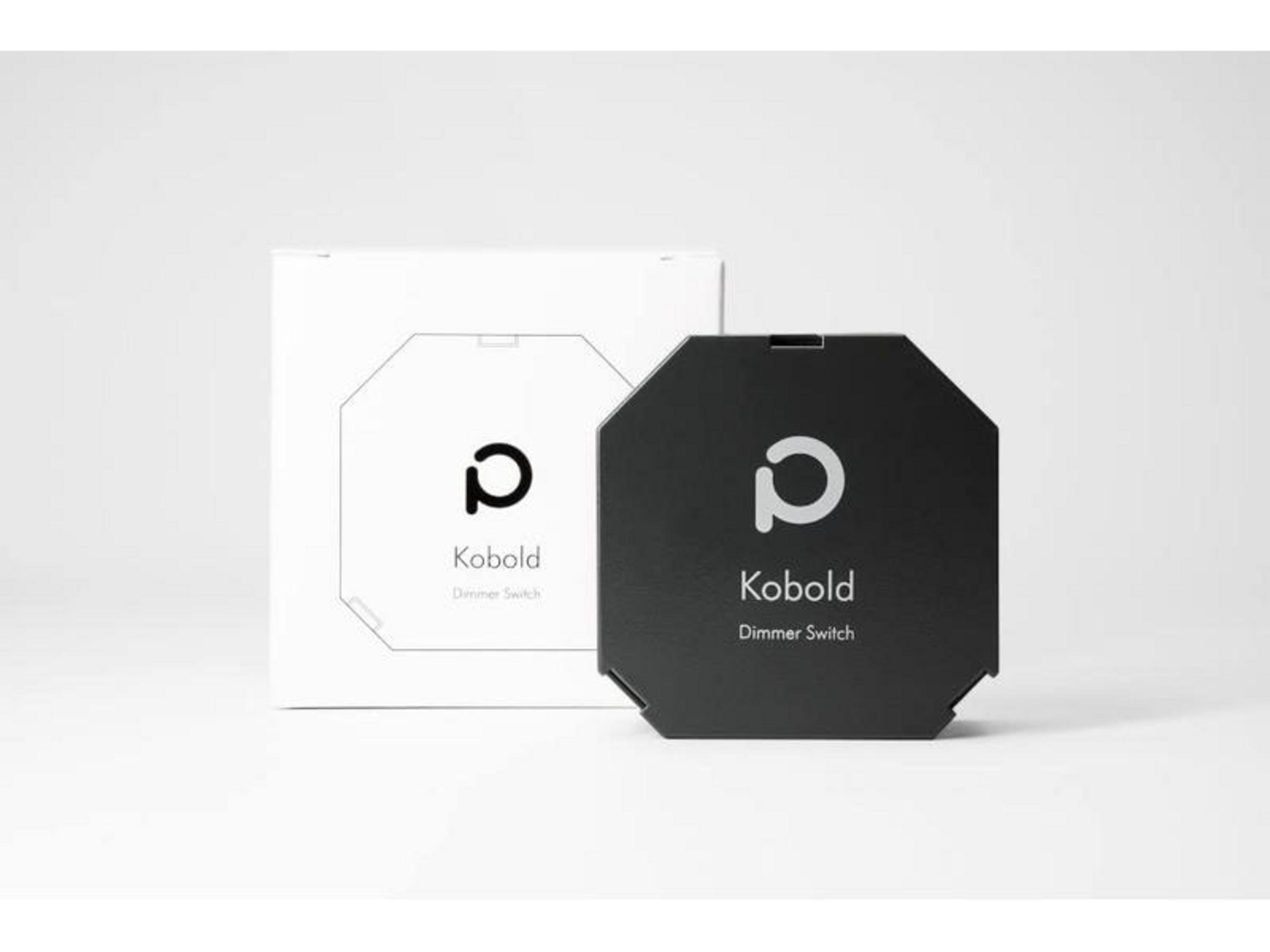 Ein schwarzer Kobold Dimmer sitzt vor seiner weißen Verpackung.