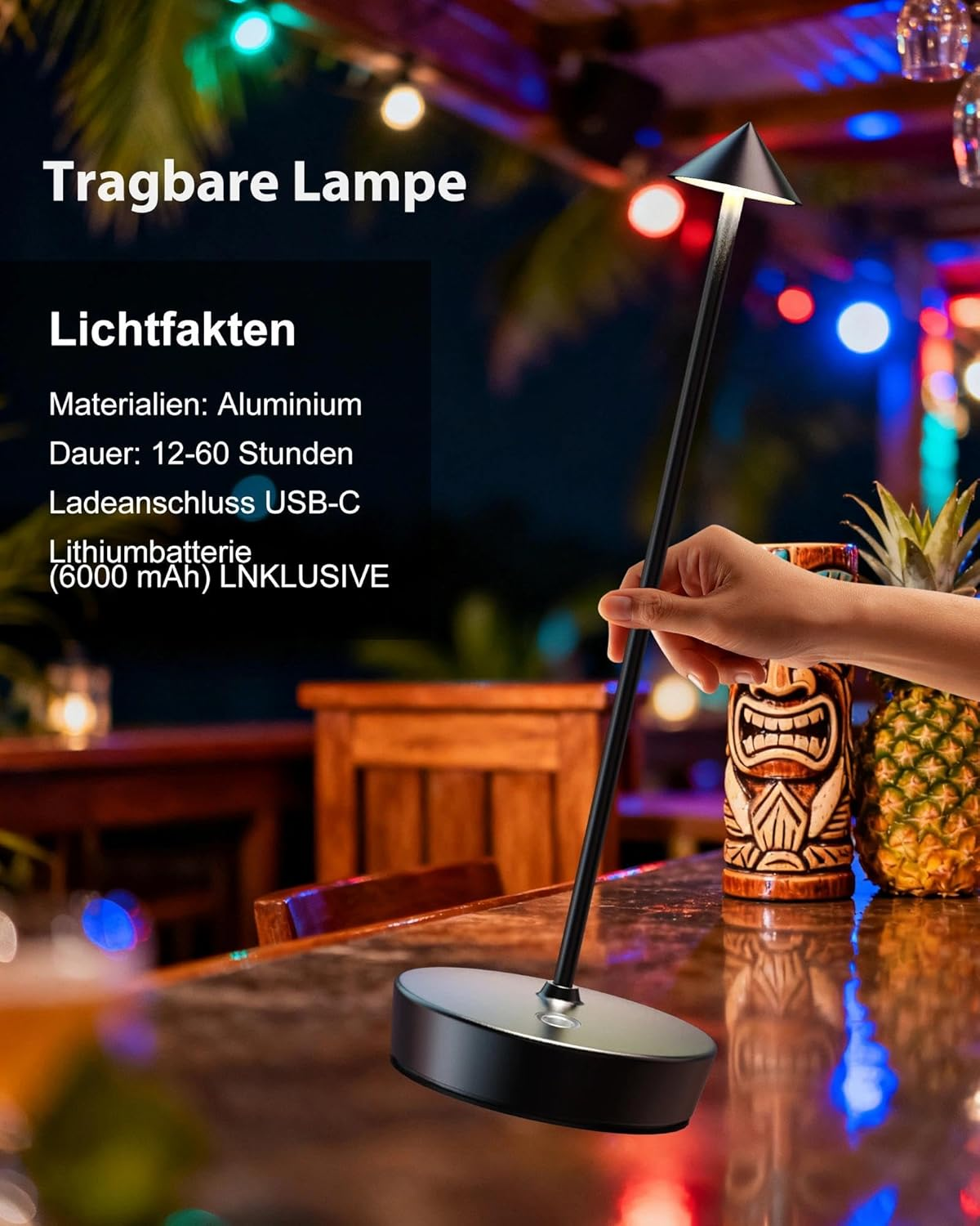 Eine Person hält eine tragbare Lampe mit Aluminiumbasis. Tiki-Maske und Ananas im Hintergrund.