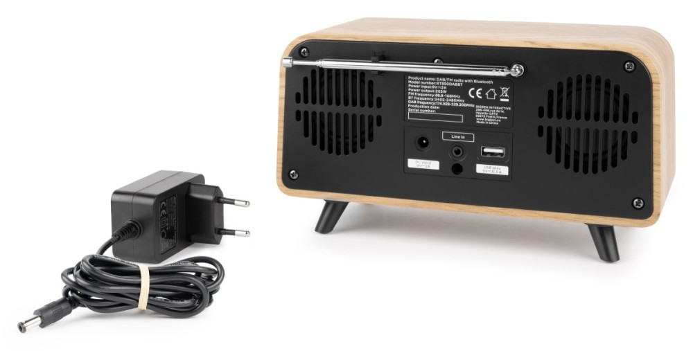 Una radio in legno con antenna e un alimentatore accanto.