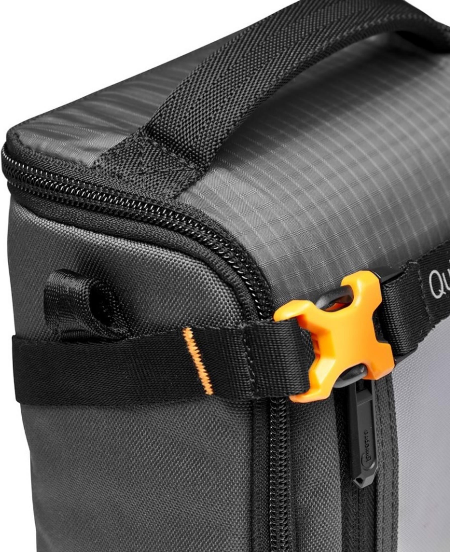 Graue Tasche mit Reißverschluss, Tragegriff und orangefarbenem Clip.