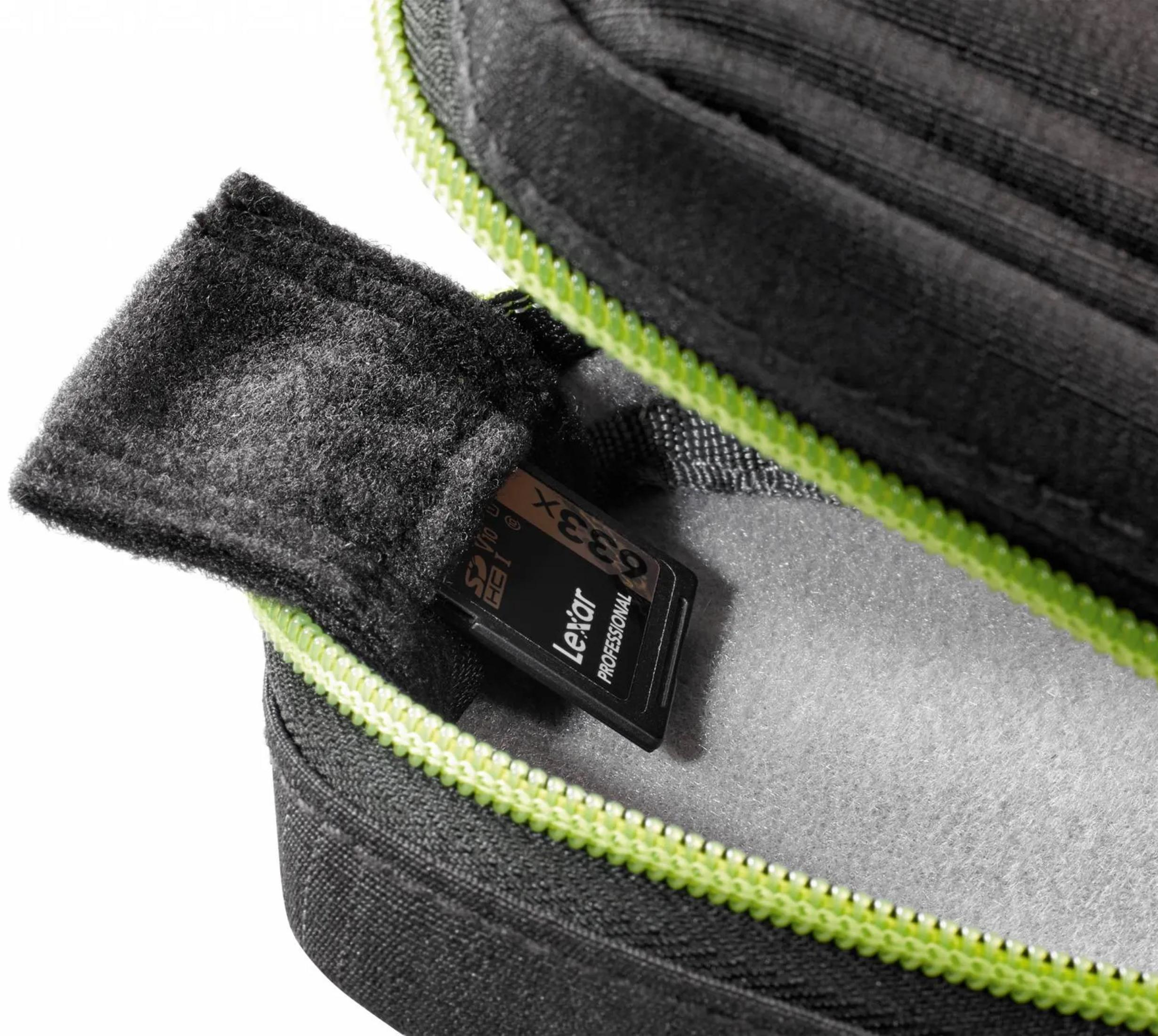 Eine SD-Karte von Lexar liegt in einem schwarzen Etui mit neongrünen Reißverschluss.