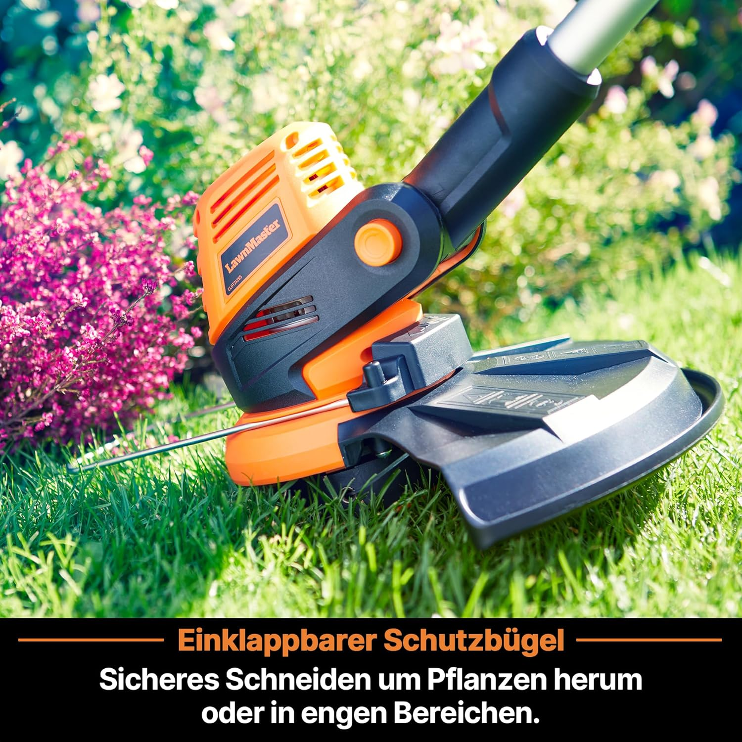 Oranger und schwarzer Rasentrimmer auf grünem Gras nahe rosa Blumen.