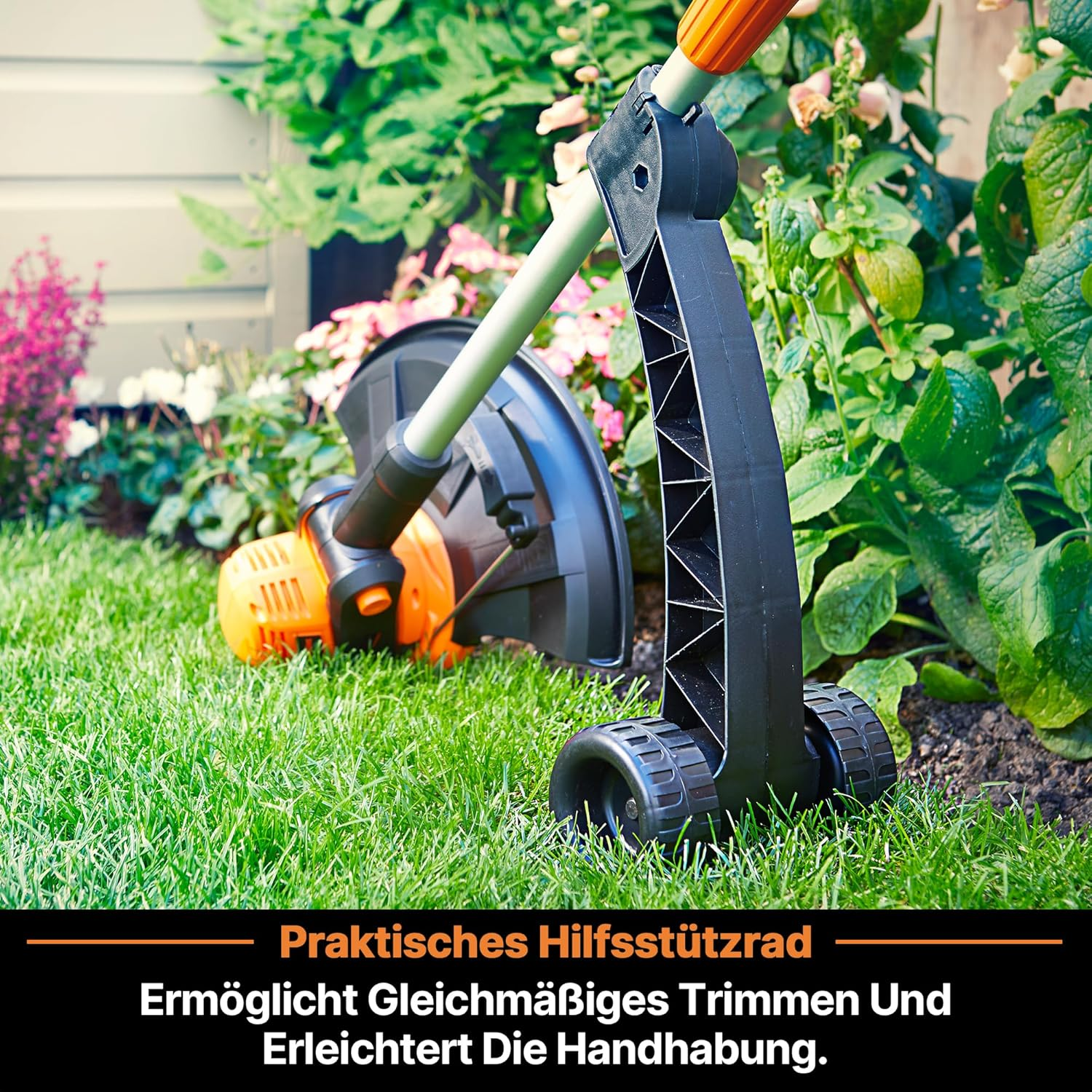 Ein Rasentrimmer mit Stützrädern steht auf grünem Gras neben Blumen.