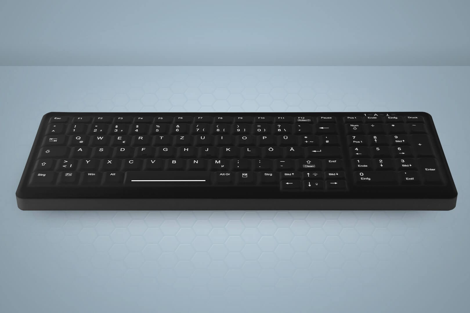 Un teclado de computadora negro y delgado con diseño de teclas alemán, sobre fondo gris.