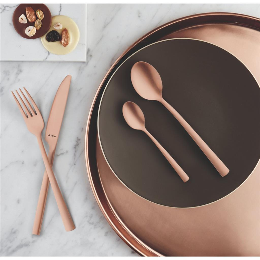Roségold-Besteckset mit Gabel, Messer und zwei Löffeln auf Marmor.
