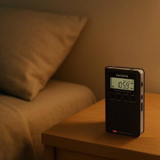 Una radio Aiwa negra está sobre una mesita de noche junto a una cama con almohada.