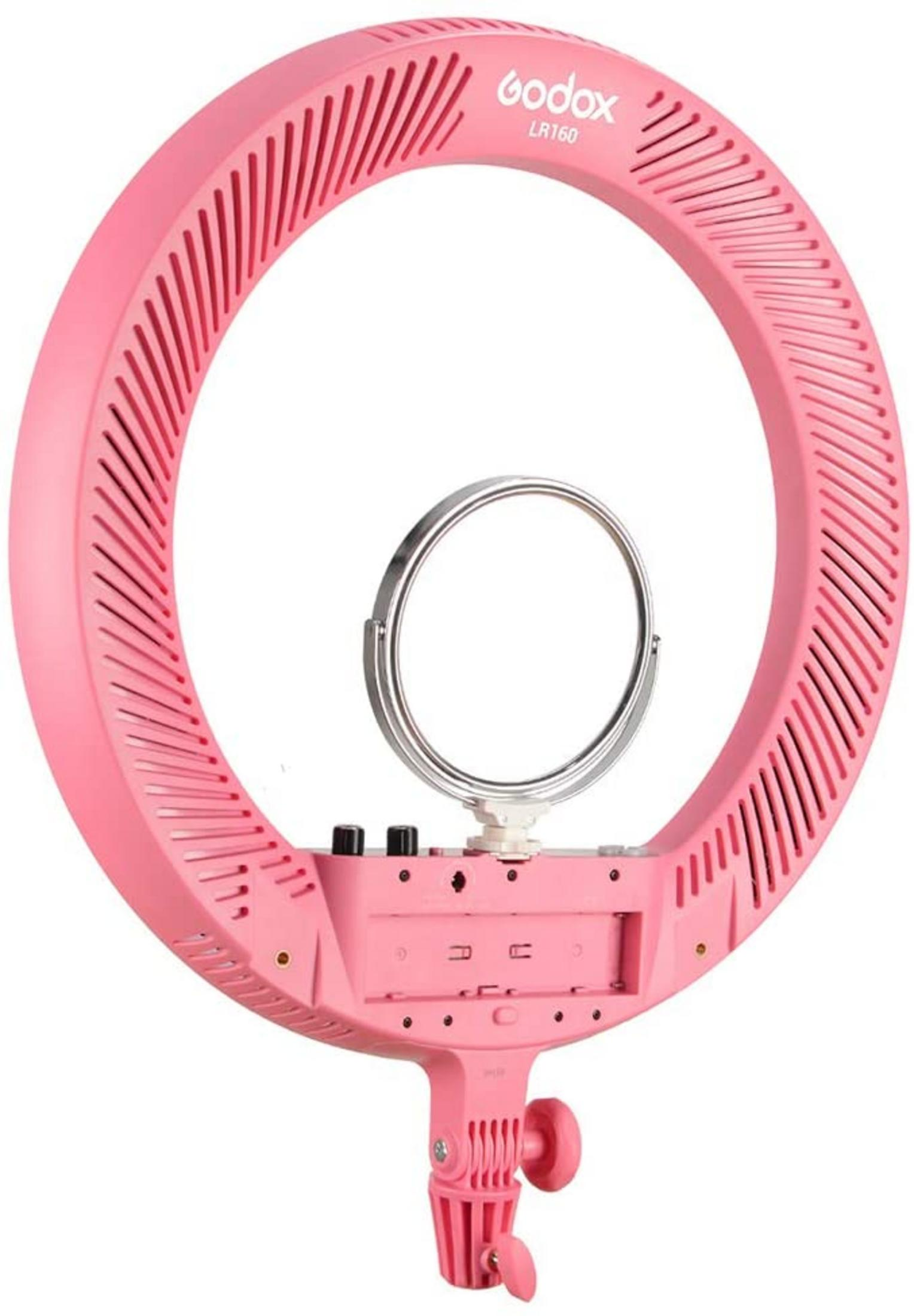 Ein pinker Ringlicht mit einem kleinen Spiegel in der Mitte. Es hat Lüftungsschlitze und Bedienelemente an der Basis.
