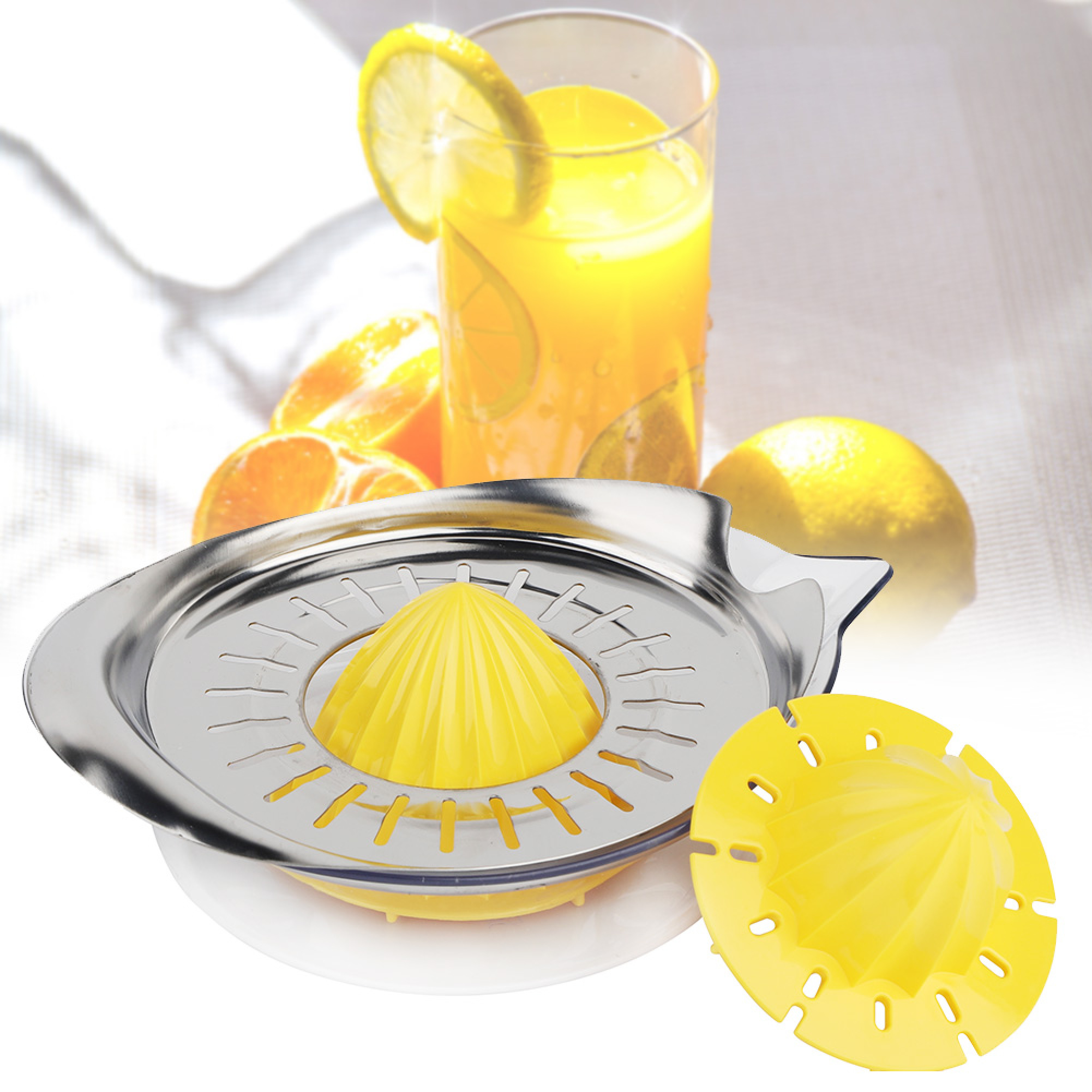 Ein gelber Zitruspresse-Einsatz neben einer Metallschale, daneben ein Glas Saft.