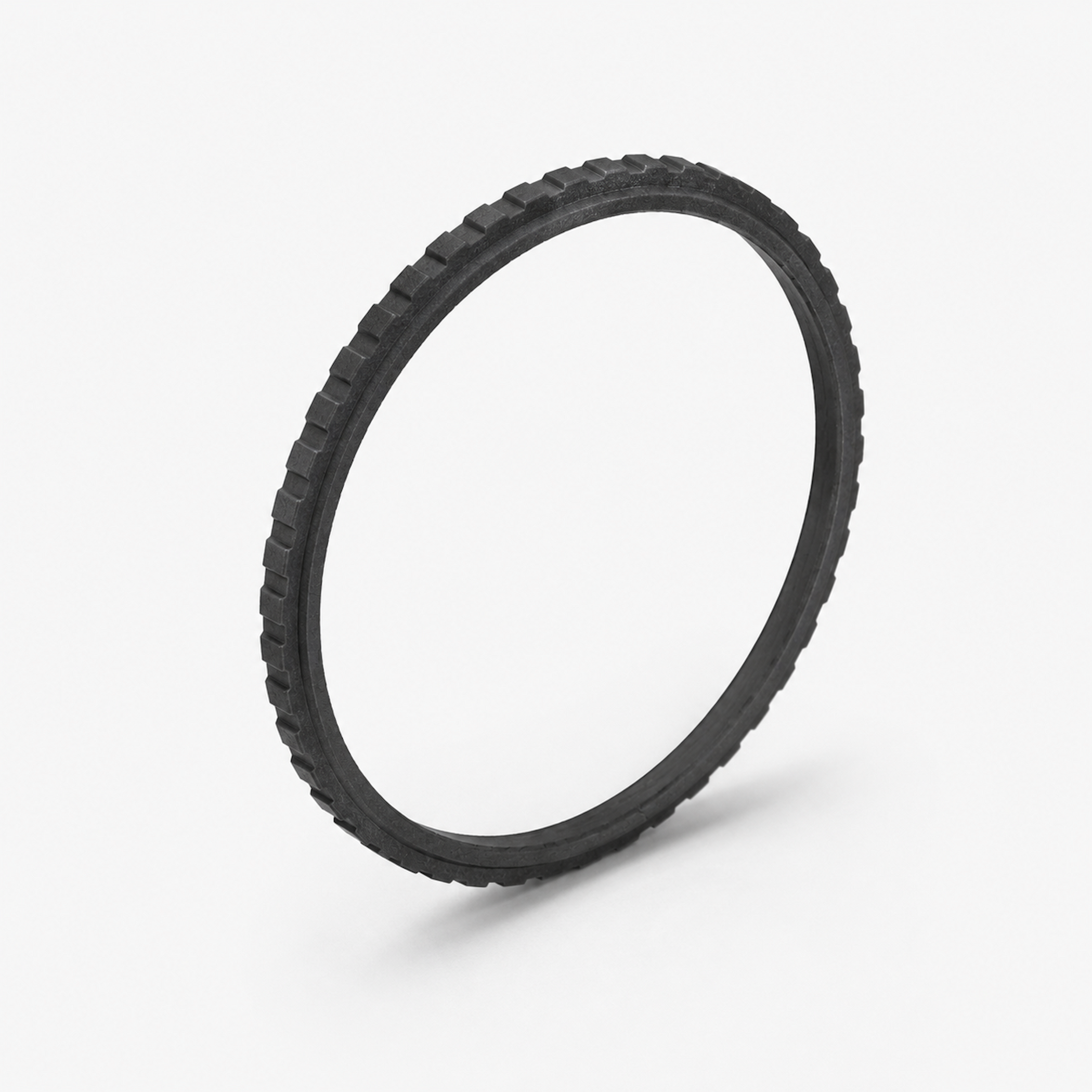Ein schwarzer, gezahnter Ring liegt auf weißem Hintergrund.