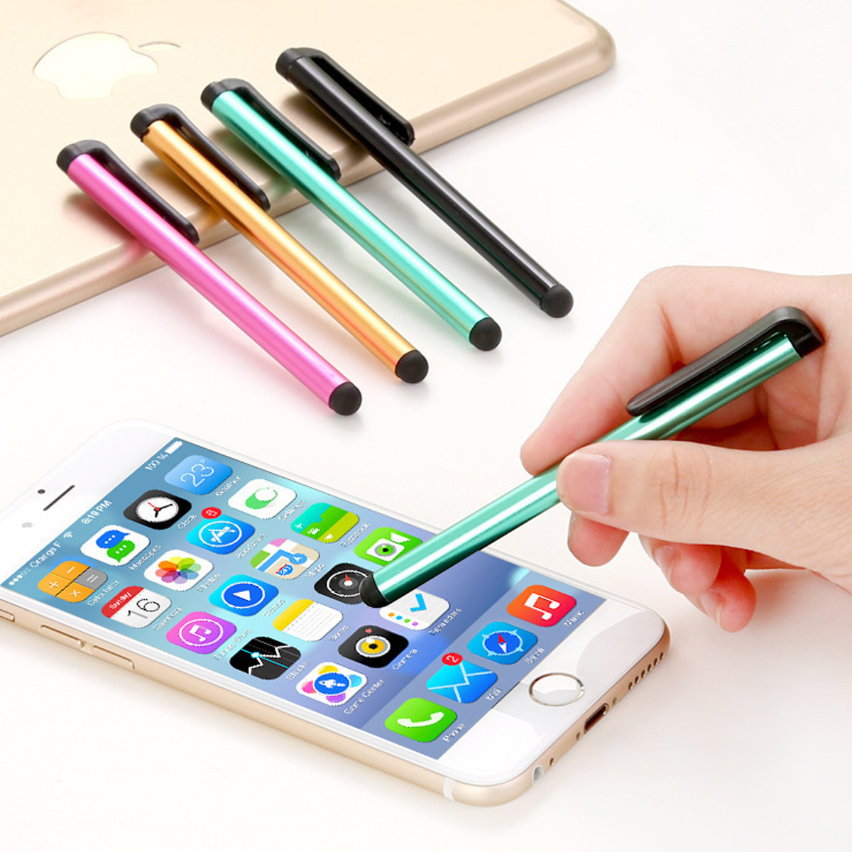 Eine Hand hält einen grünen Stift auf einem Telefonbildschirm. Vier andere Stifte liegen auf einem Telefon.
