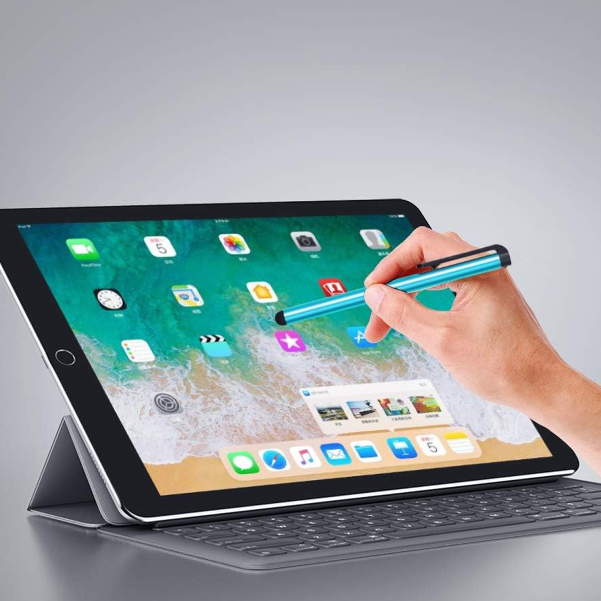 Eine Hand benutzt einen blauen Stift, um ein Tablet mit vielen App-Symbolen zu bedienen.