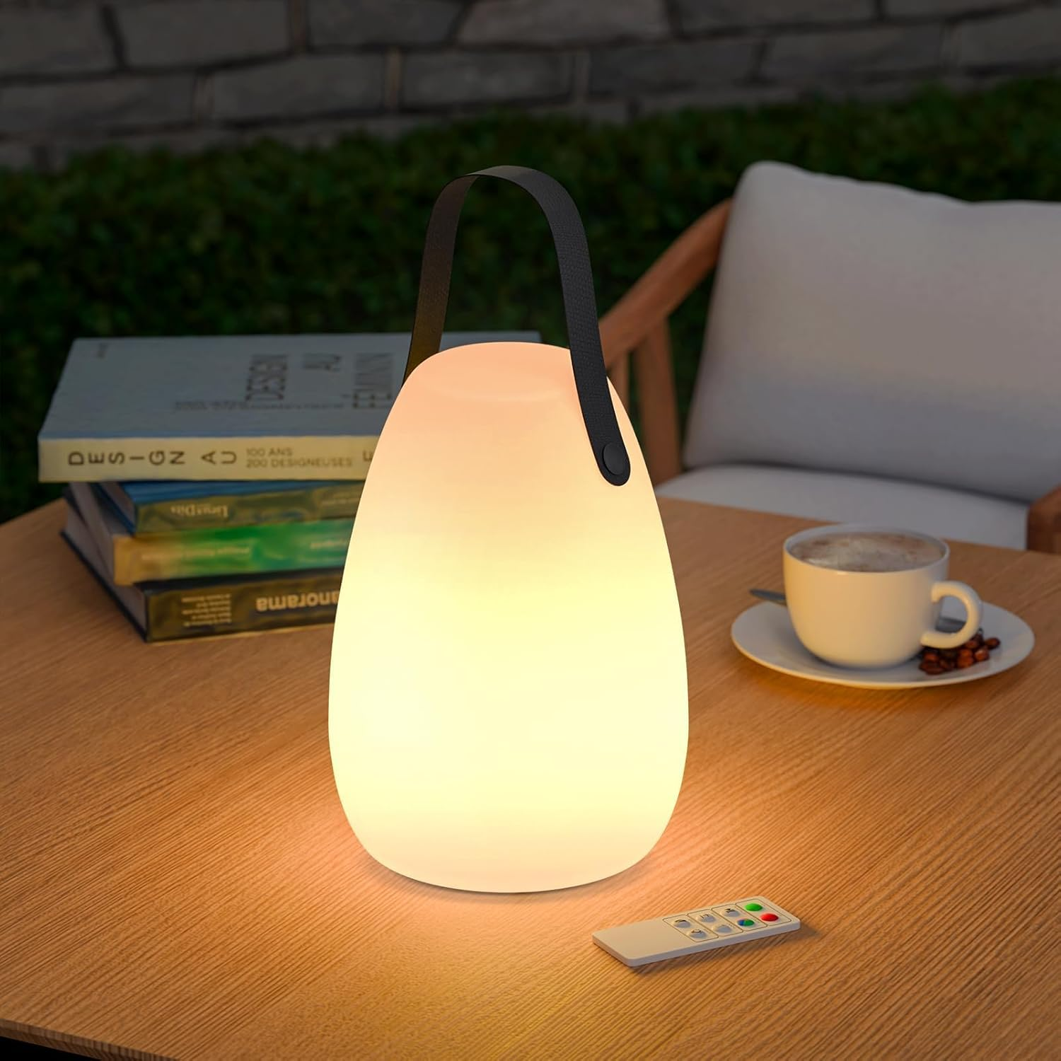 Eine leuchtende Lampe mit Henkel steht auf einem Holztisch neben Büchern und einer Kaffeetasse.
