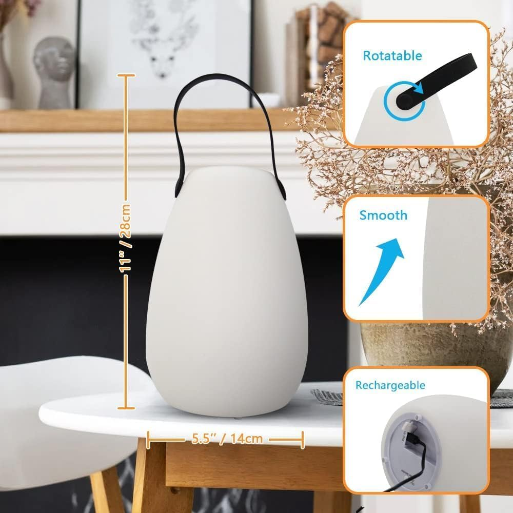 Eine weiße, tropfenförmige Lampe mit schwarzem Griff steht auf einem Tisch.