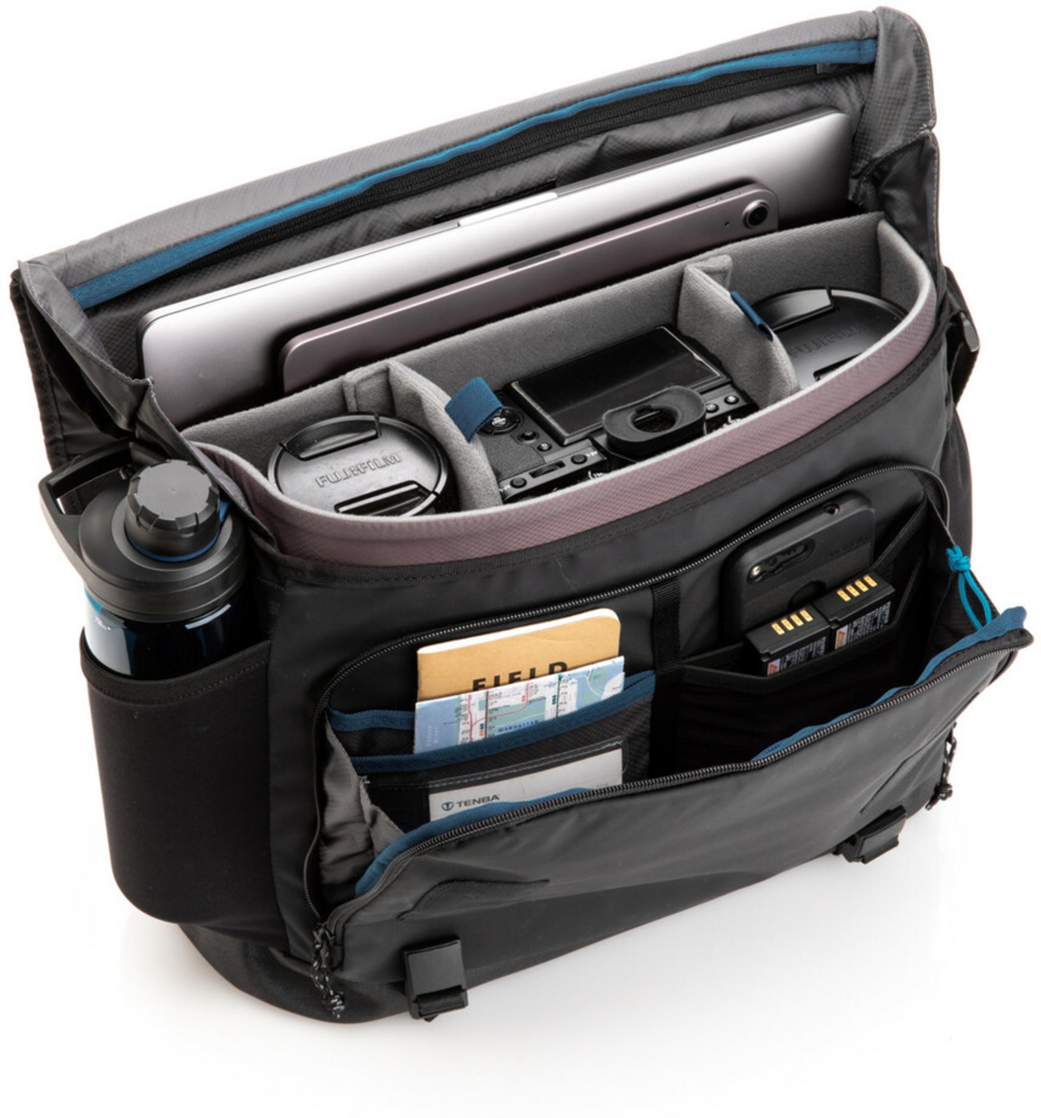 Open black messenger bag with laptop, tablet, camera, water bottle, and batteries.