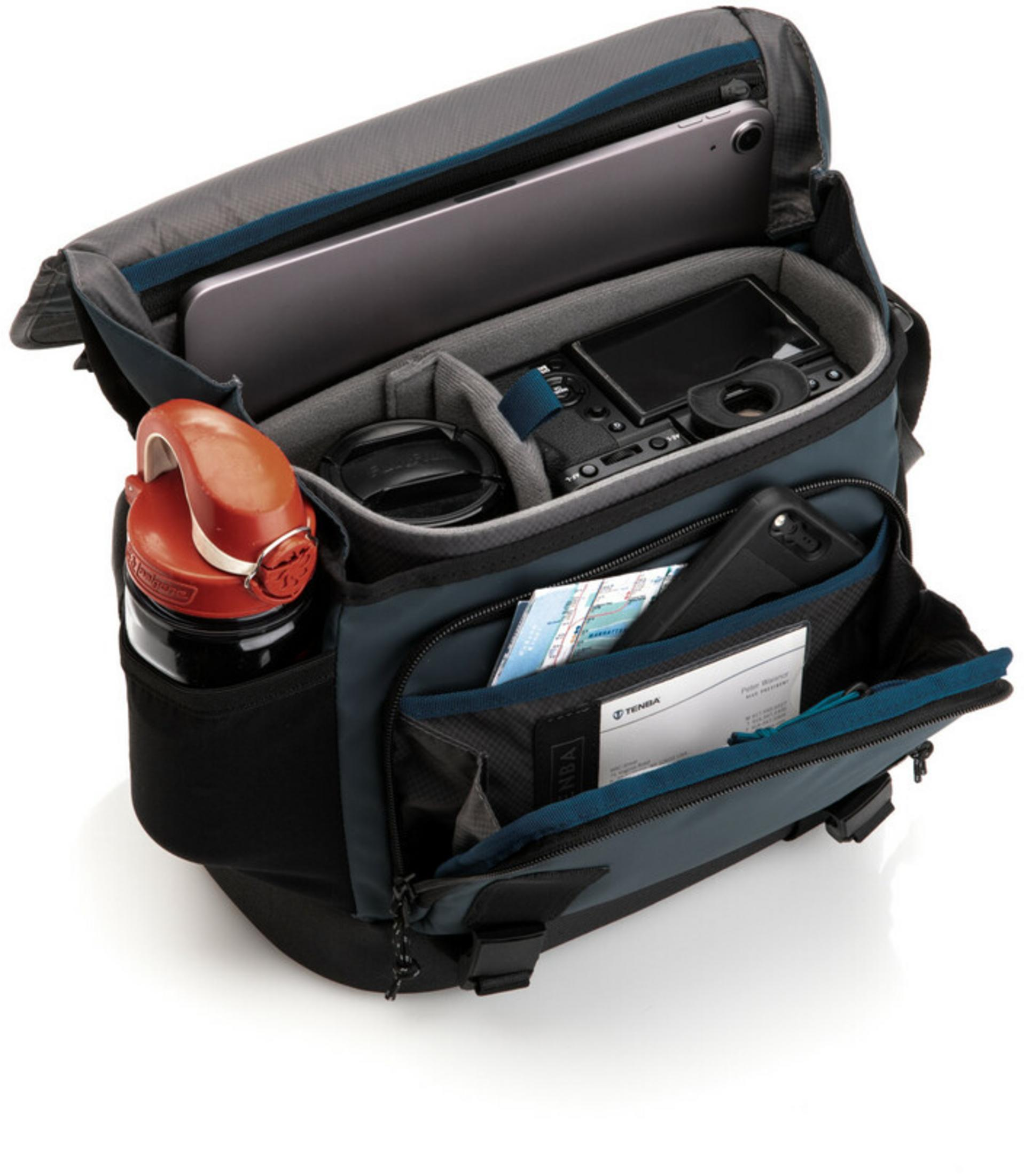 An open camera bag with a laptop, camera, lens, phone, and water bottle inside.
