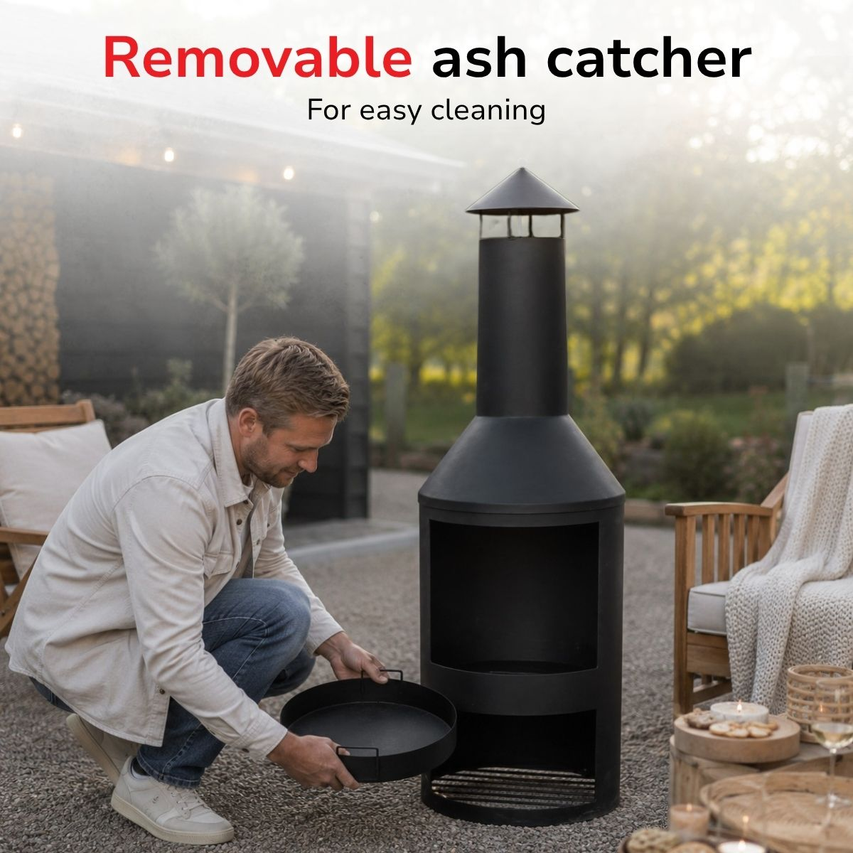 Man removes ash catcher from black outdoor fireplace.