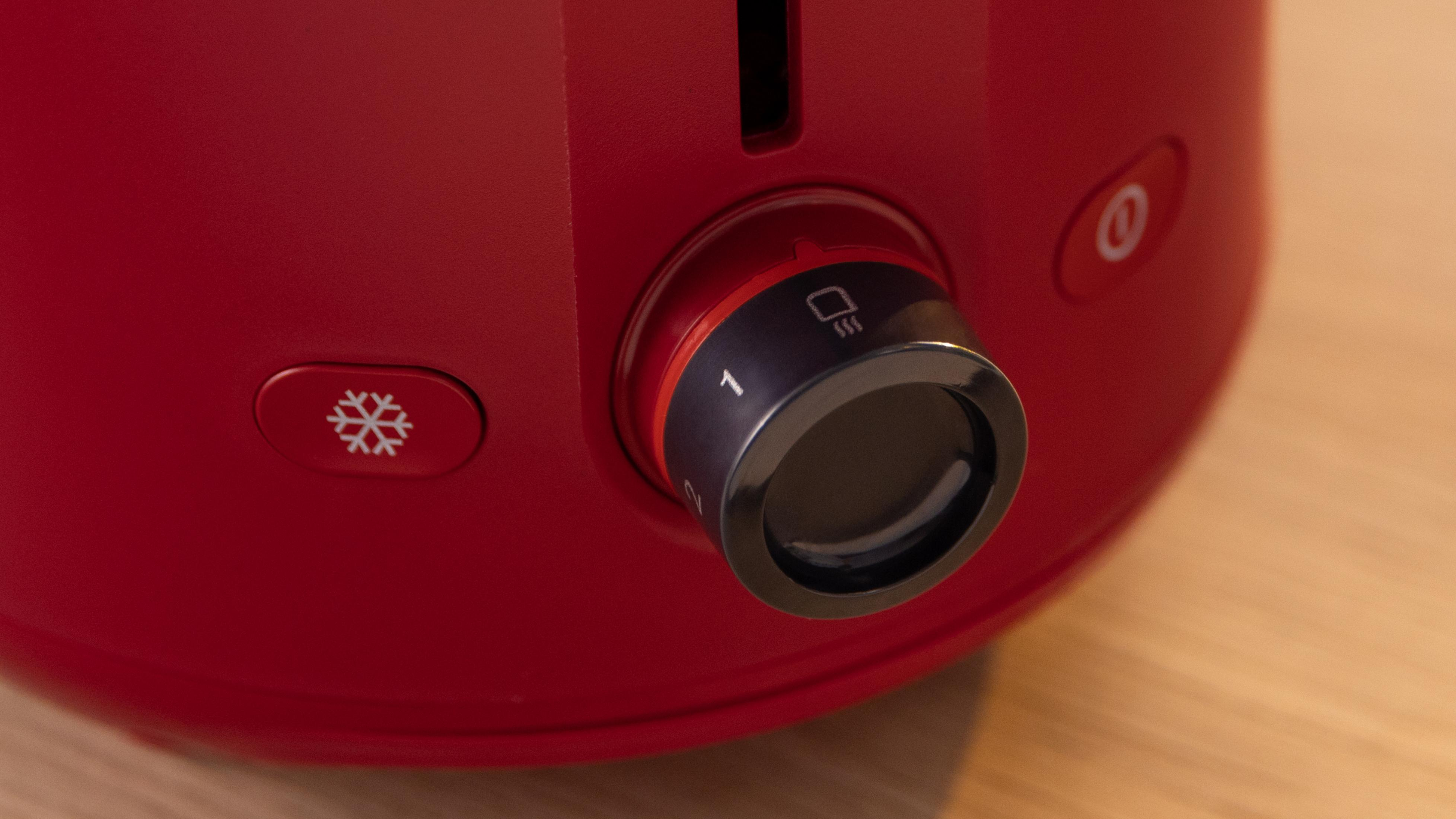 Roter Toaster mit Einstellknopf und Schneeflockensymbol.