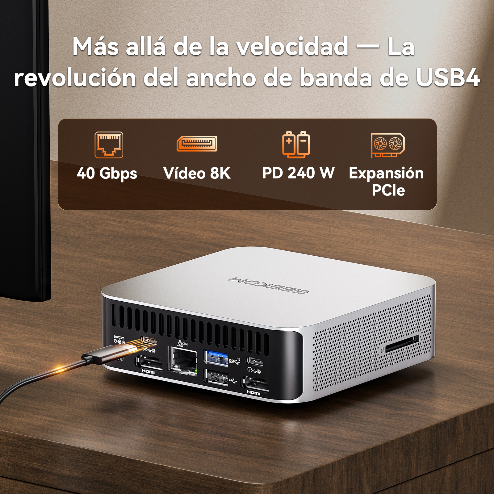 Un mini PC plateado con varios puertos, con un cable enchufado.