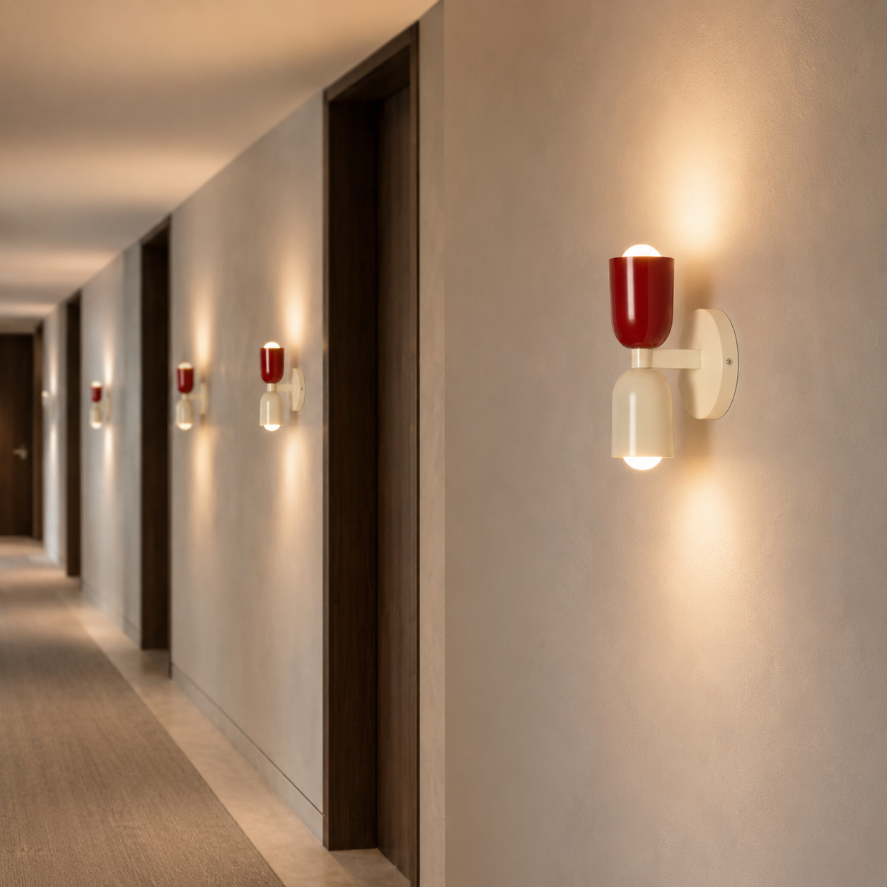 Un pasillo con puertas de madera y apliques de pared rojos y crema.
