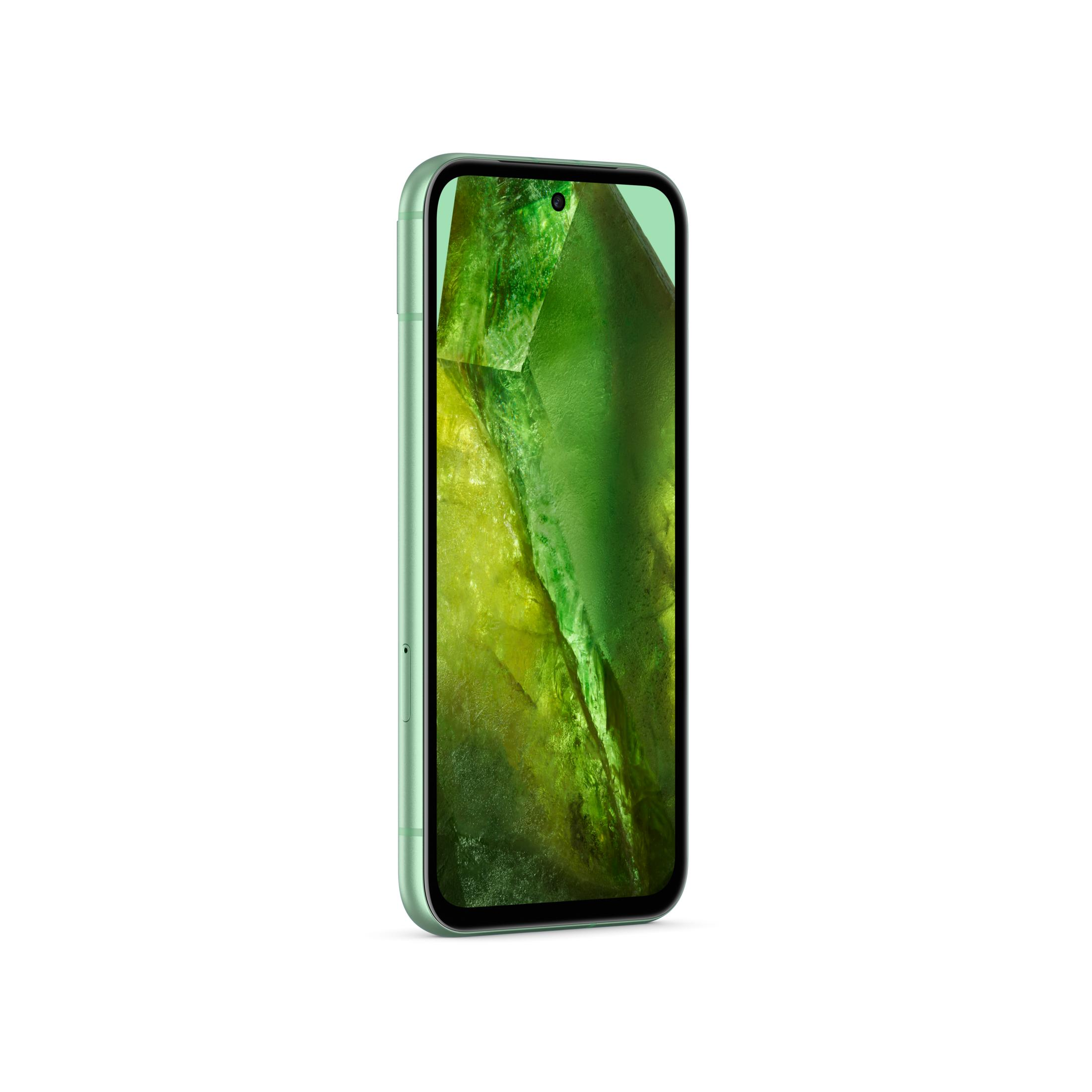 Jasnozielony smartfon wyświetlający zielone i żółte kryształy na ekranie.