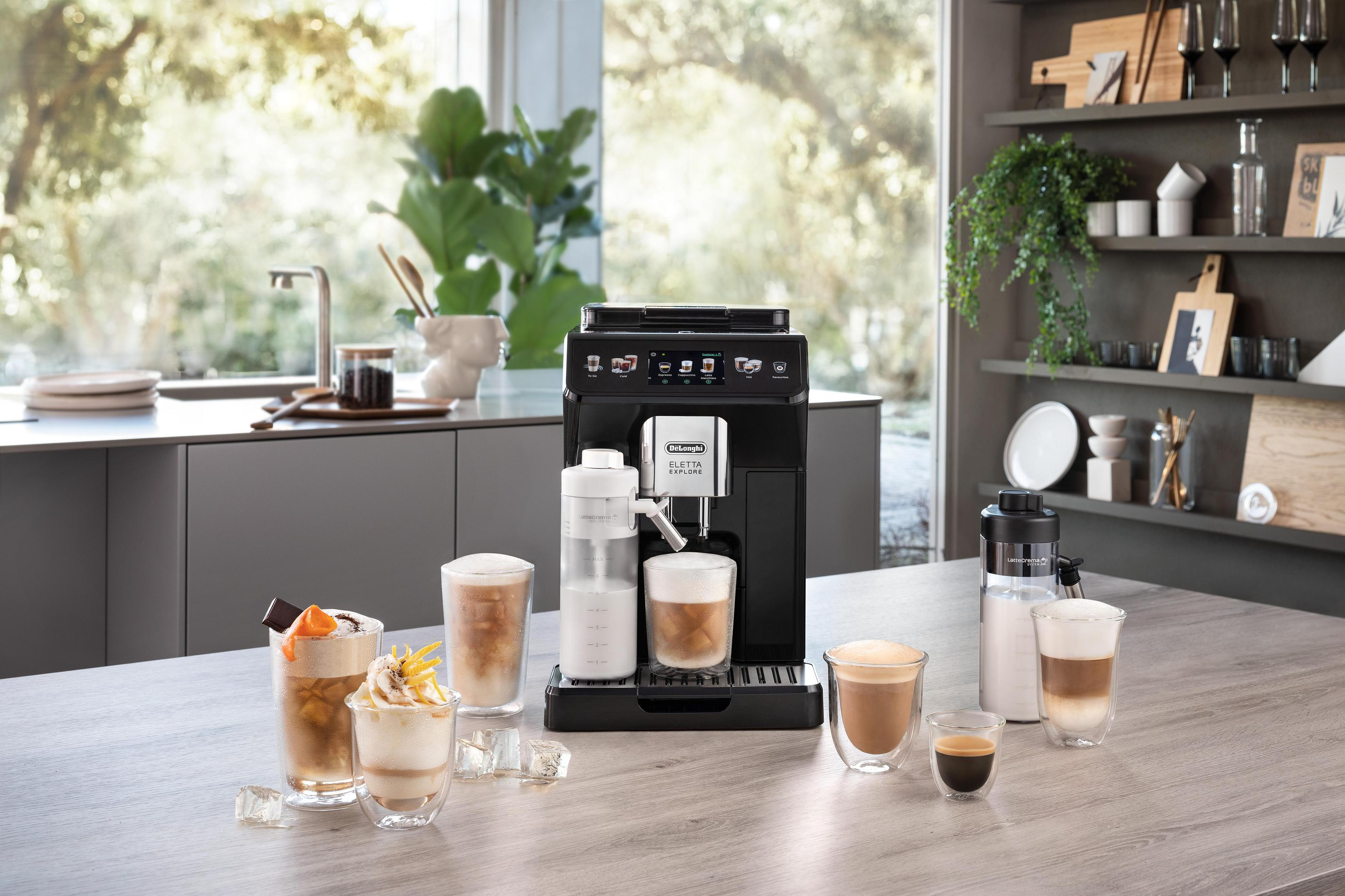 Una macchina da caffè nera su un bancone di legno con varie bevande al caffè.