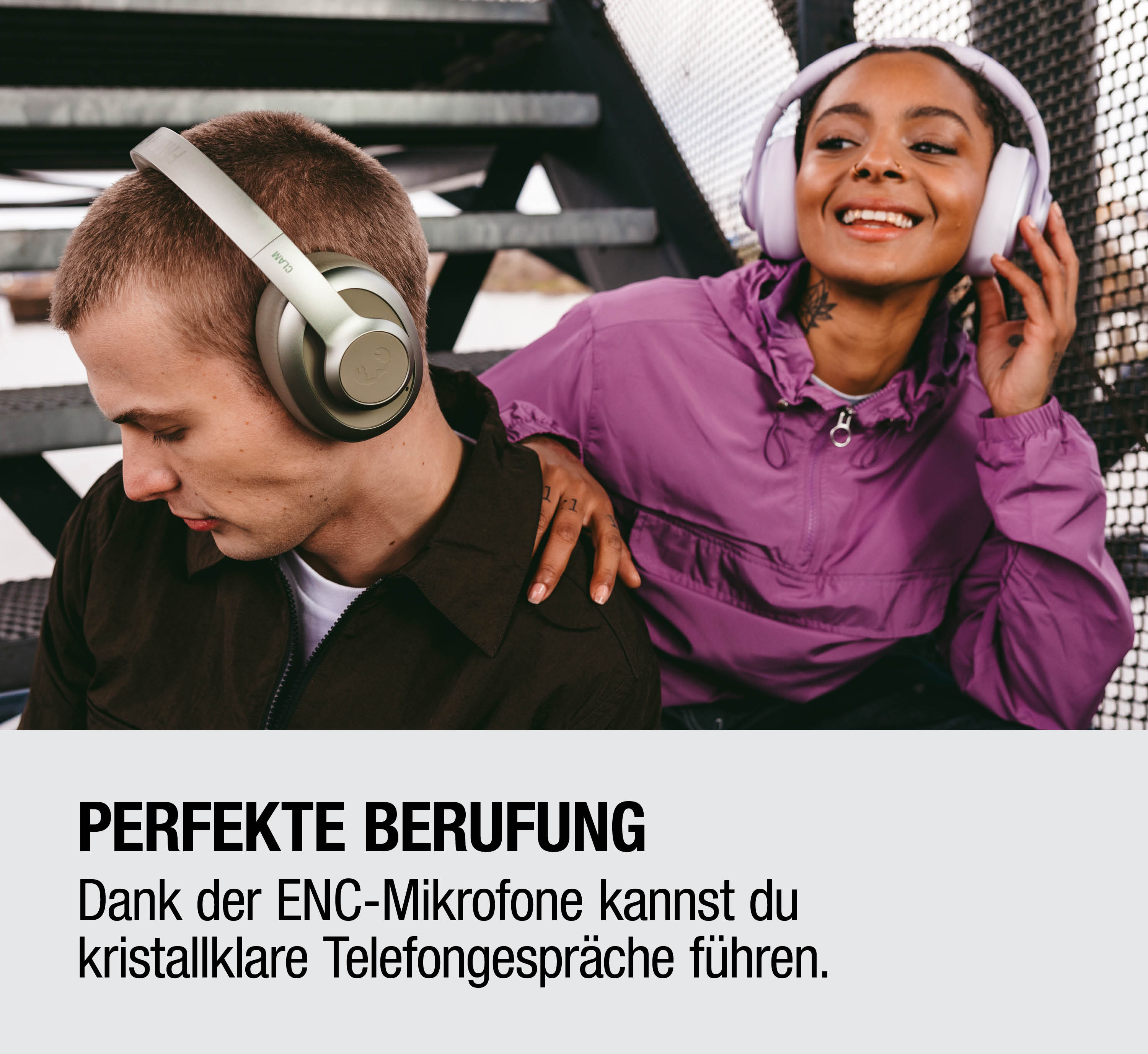 Mann mit grünen Kopfhörern, Frau mit lila Jacke und Kopfhörern lächelt.