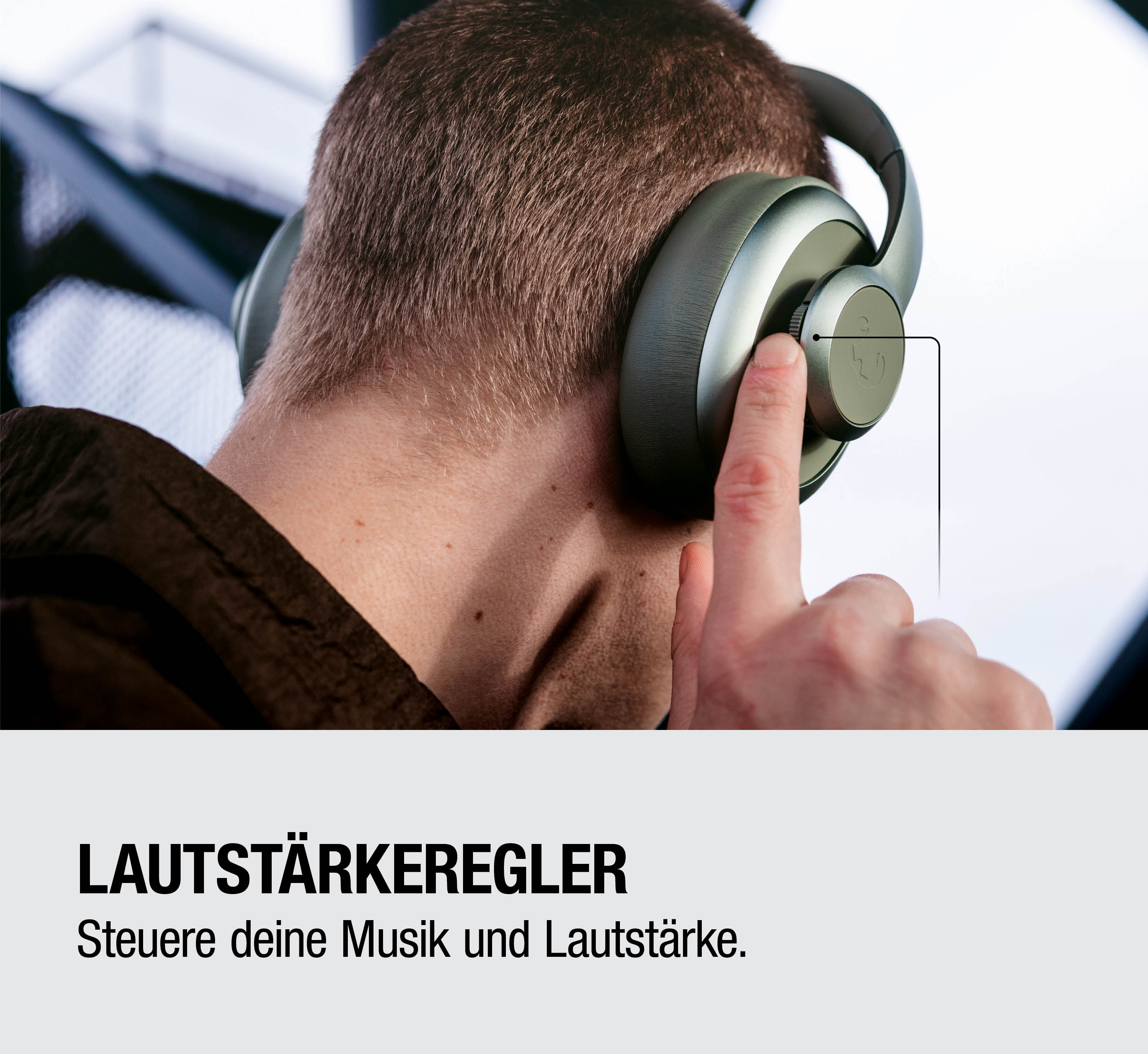 Mann mit Kopfhörern bedient Lautstärkeregler mit Finger.