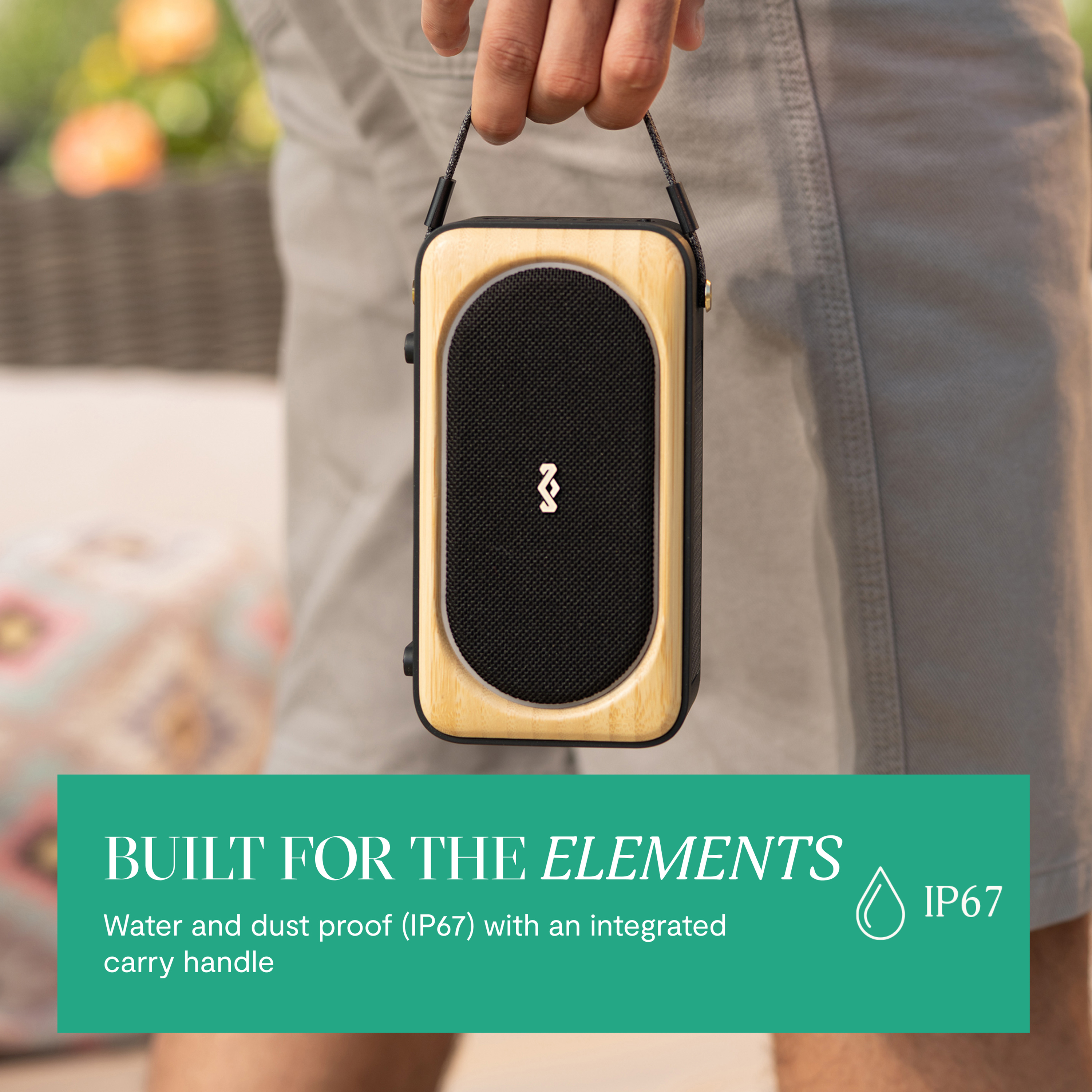 Una mano tiene uno speaker Bluetooth resistente all'acqua con cornice in legno.